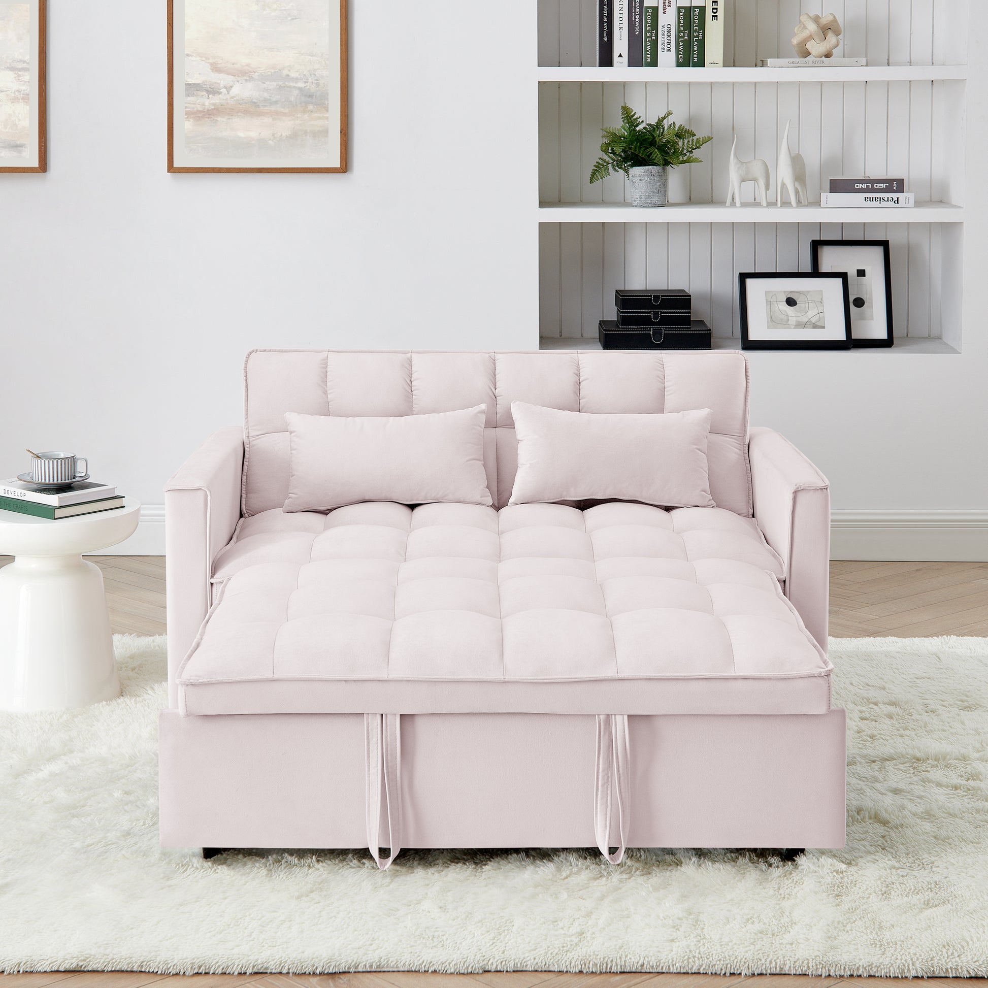 Soft pink velvet sofa bed with tufted cushioning featuring pull straps for conversion