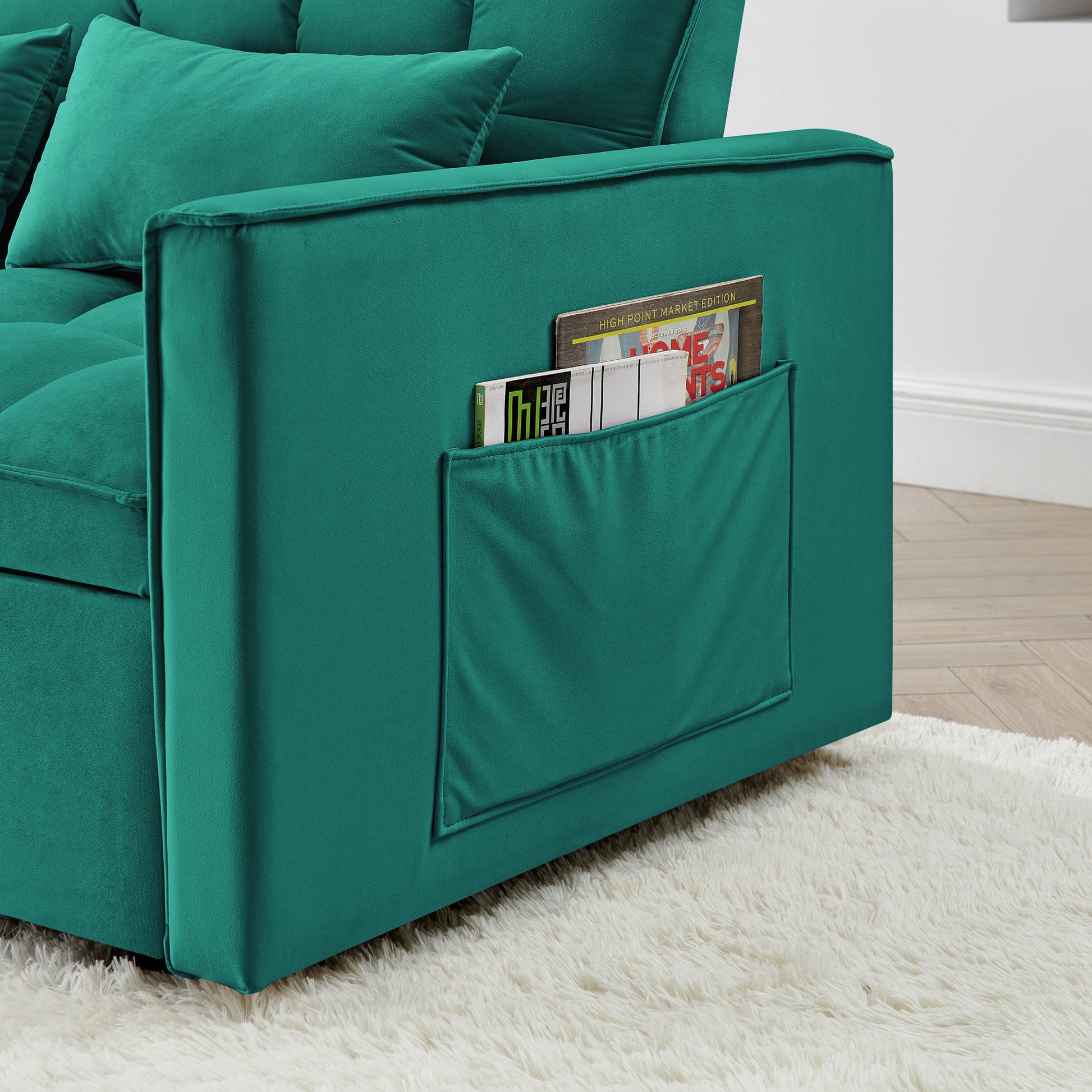 Teal velvet sofa with integrated magazine pocket on armrest