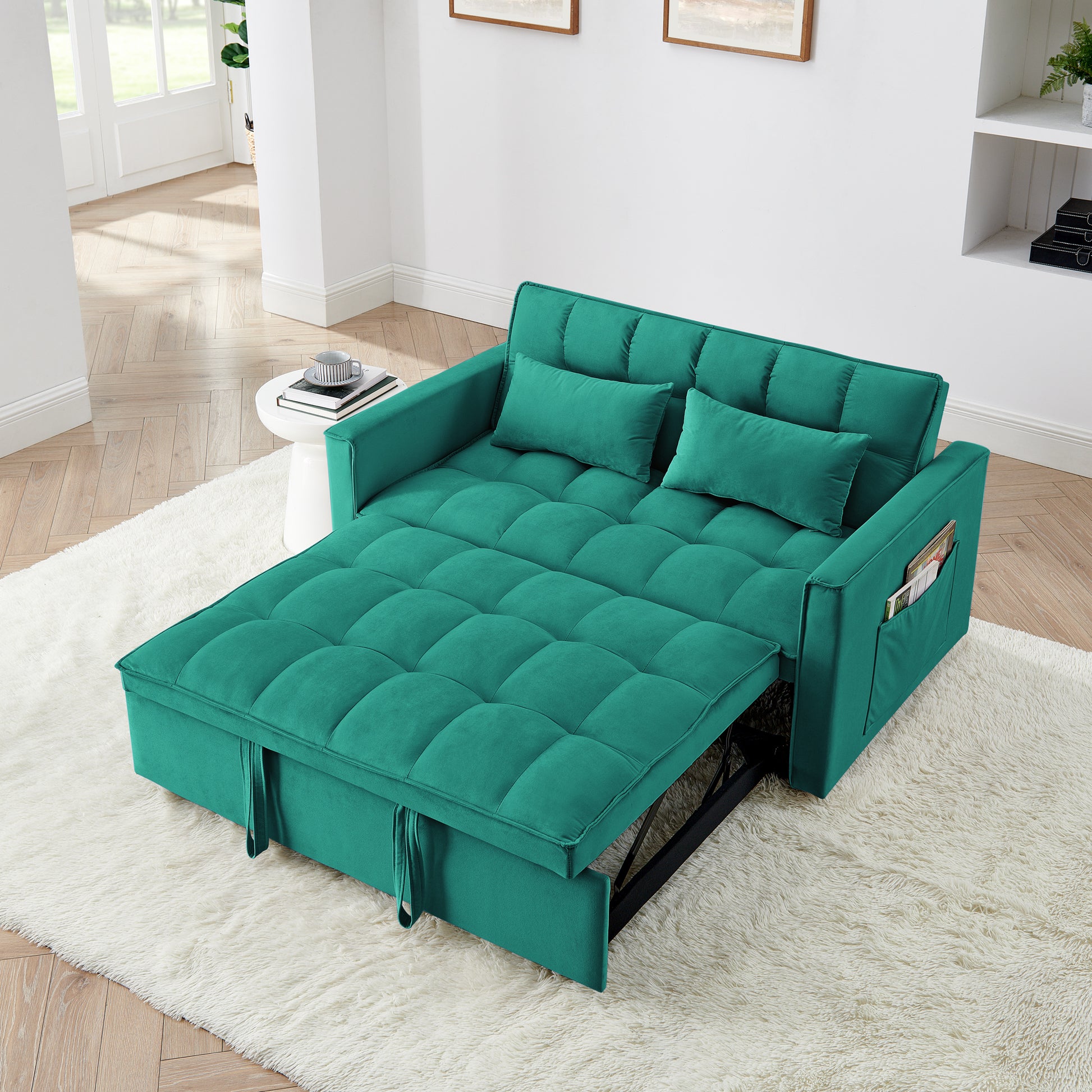 Teal velvet sofa bed with tufted cushioning and two accent pillows