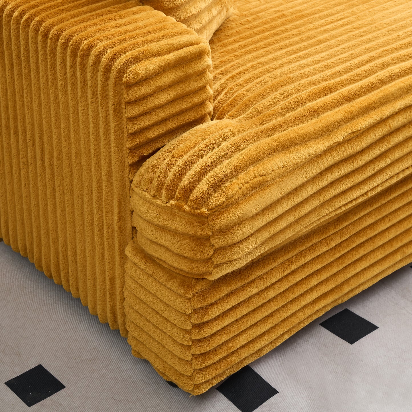Plush mustard corduroy sofa detail showing thick horizontal ribbing for comfortable seating
