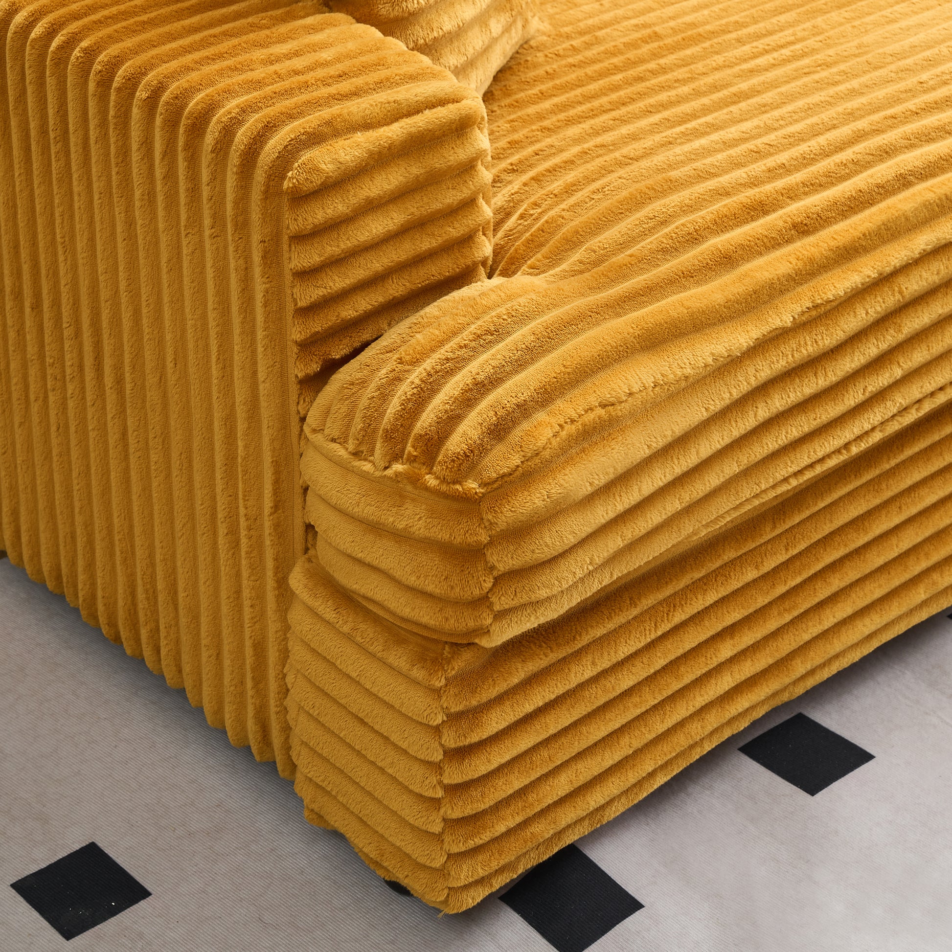 Plush mustard corduroy sofa detail showing thick horizontal ribbing for comfortable seating