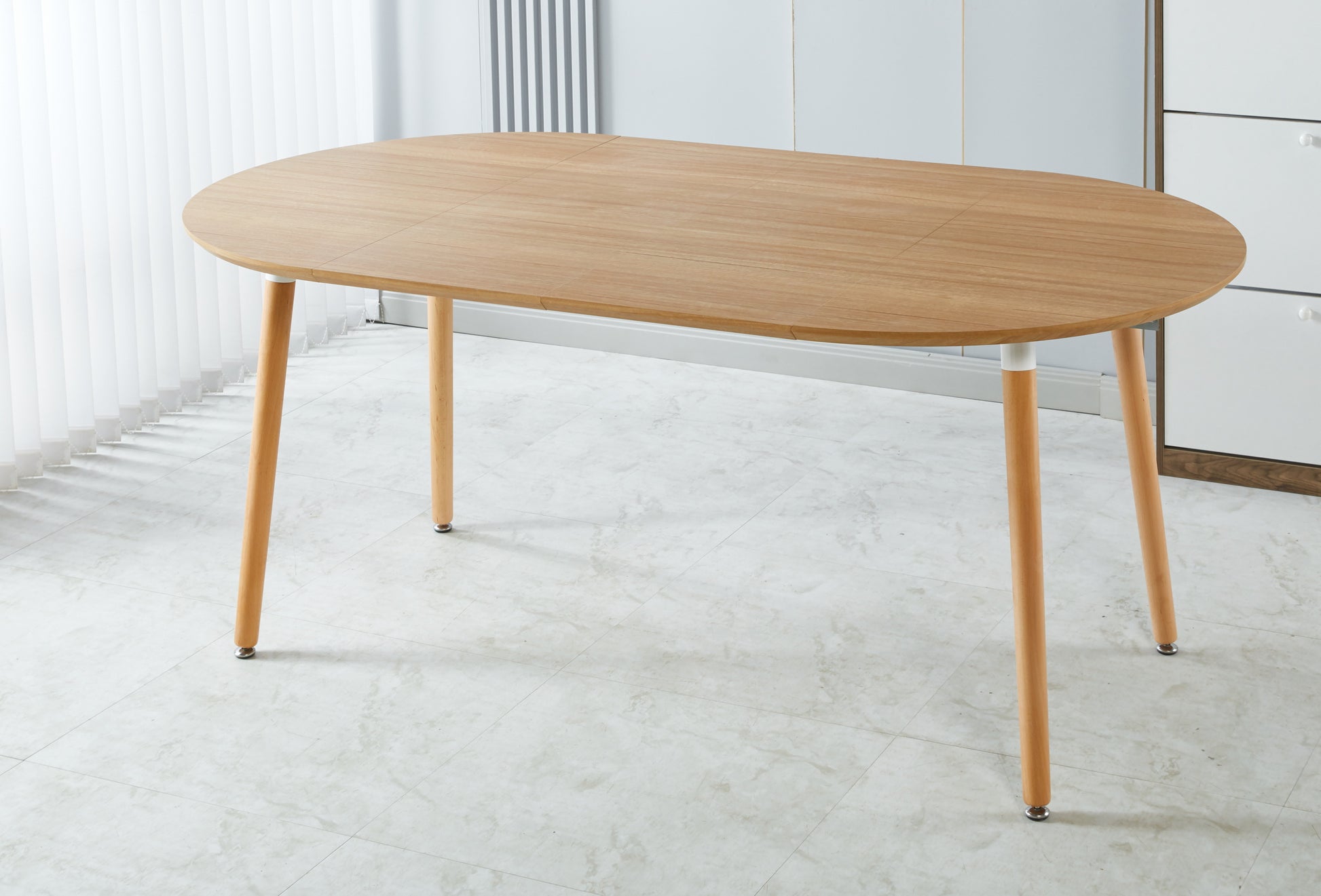 Light wood oval dining table with tapered legs perfect for modern kitchens