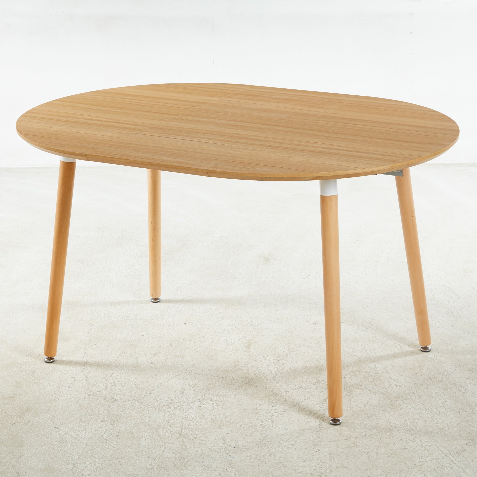 Light wood oval dining table with tapered legs