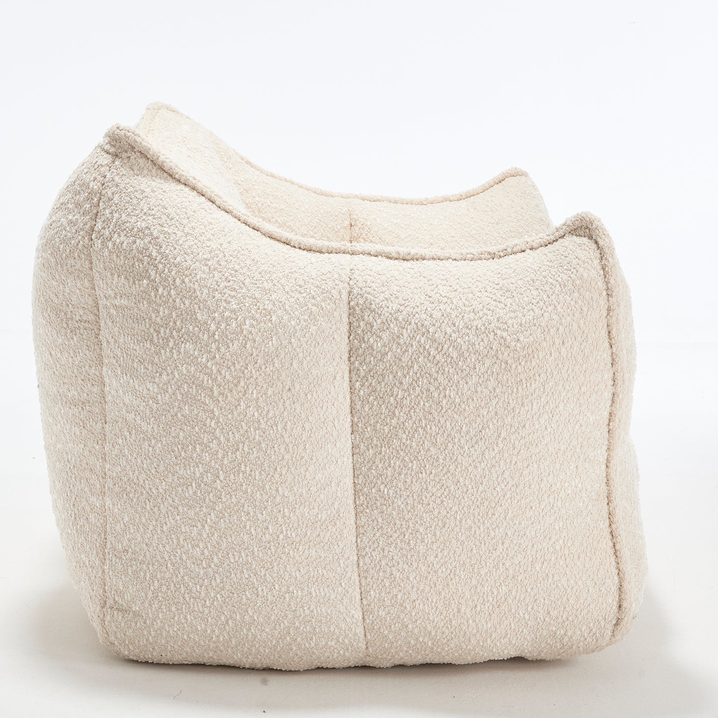 Cream boucle fabric floor pouf with a comfortable curved design for modern living spaces