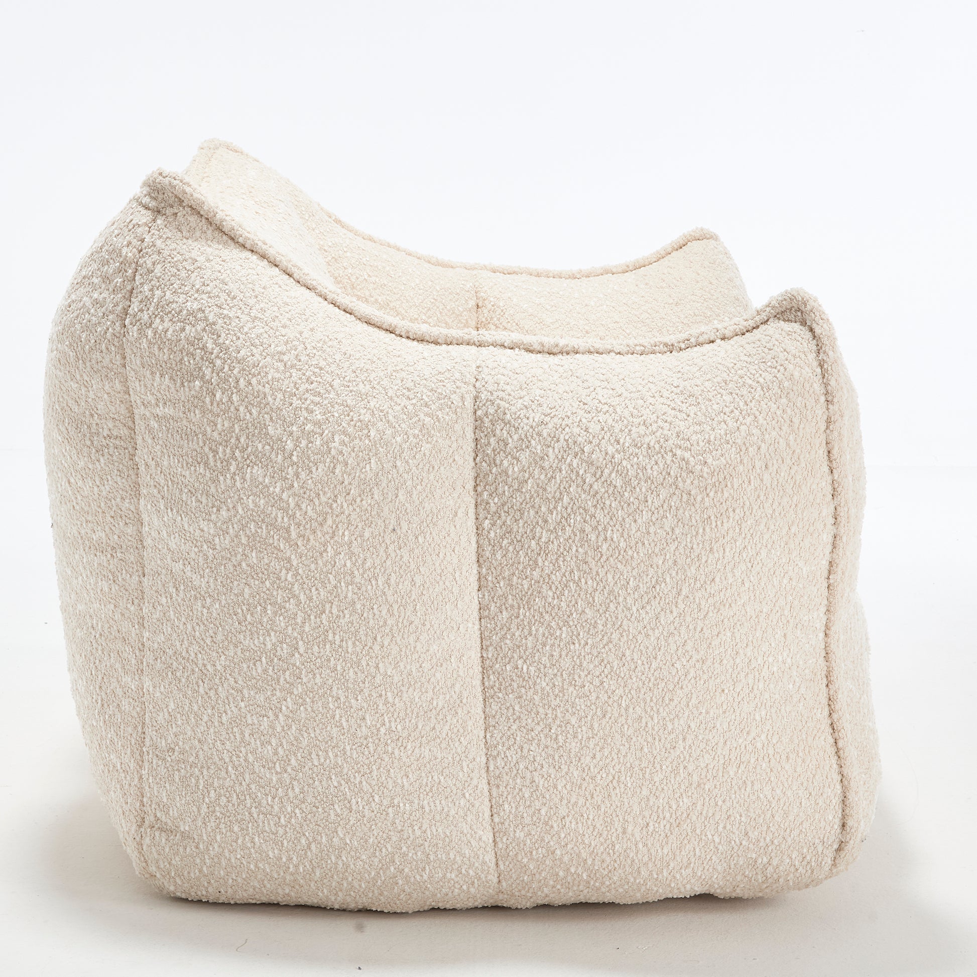 Cream boucle fabric floor pouf with a comfortable curved design for modern living spaces