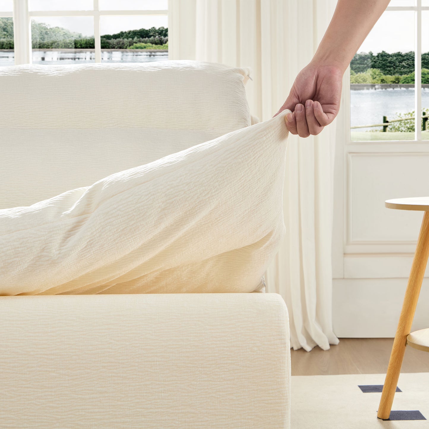 Cream textured sofa cover being applied providing a fresh look