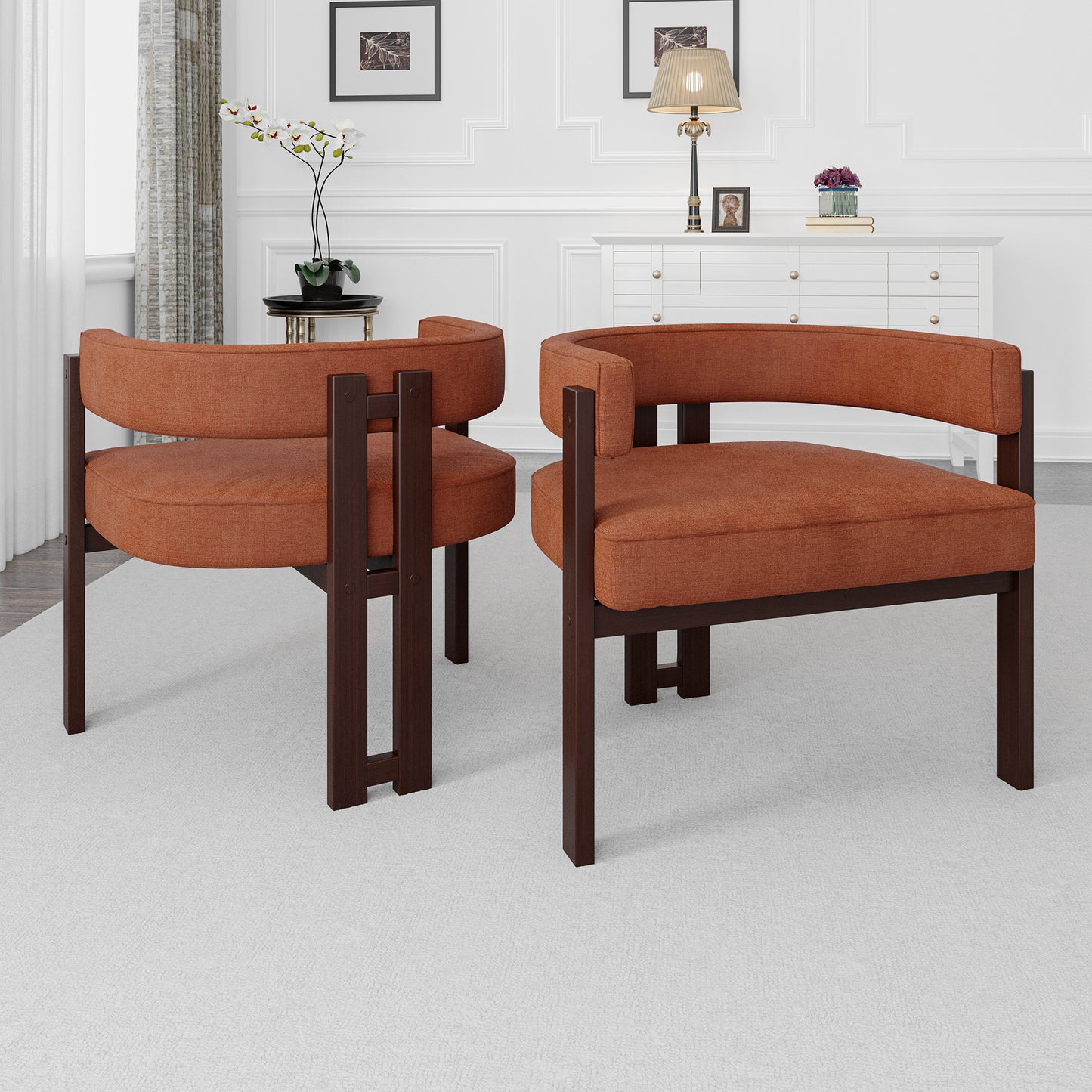 Two burnt orange upholstered accent chairs with dark wood frames sit on a rug