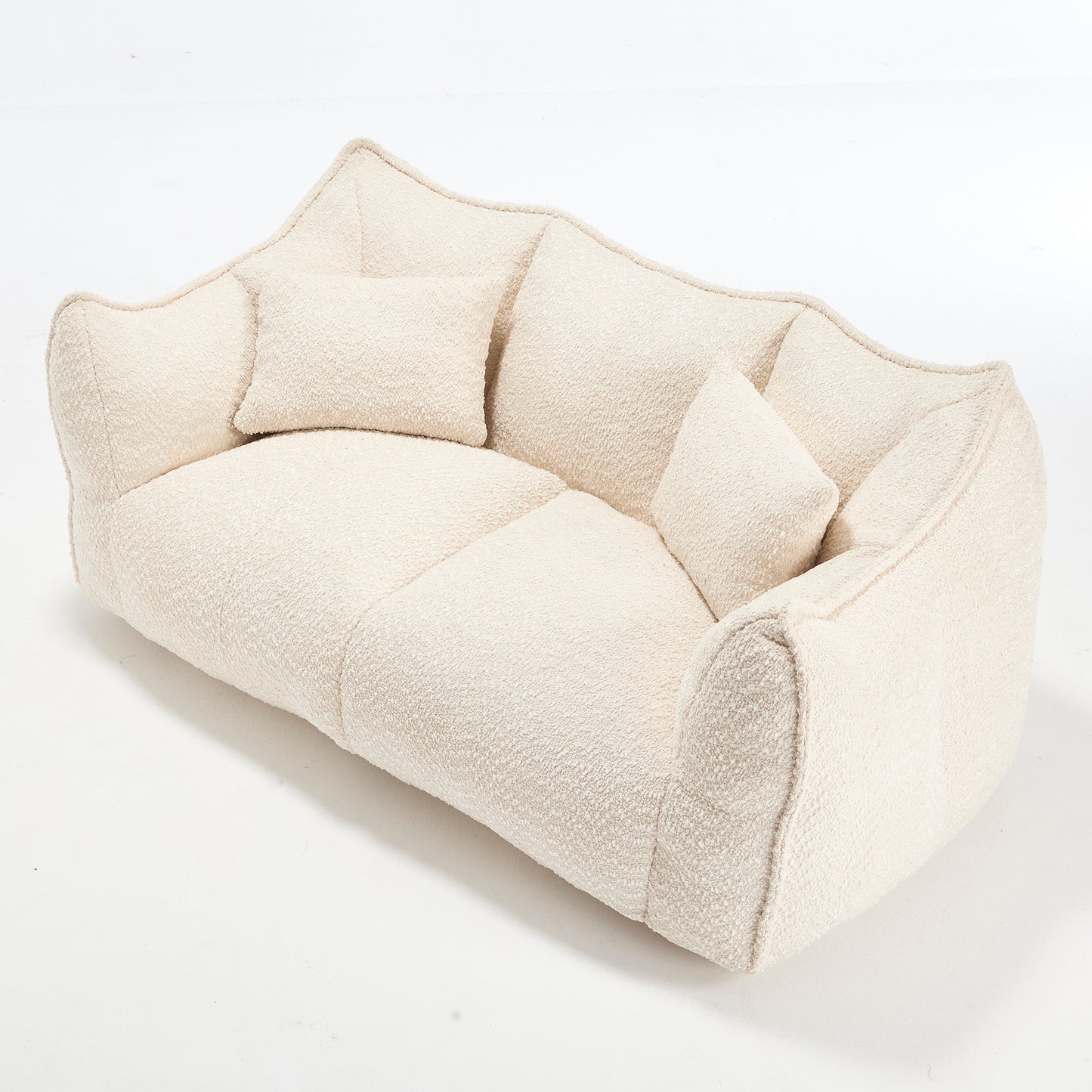 Plush cream boucl fabric sofa with asymmetrical design and two throw pillows