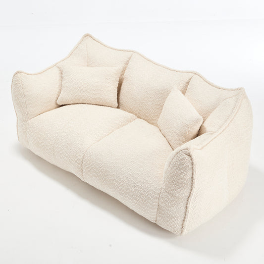 Plush cream boucl fabric sofa with asymmetrical design and two throw pillows