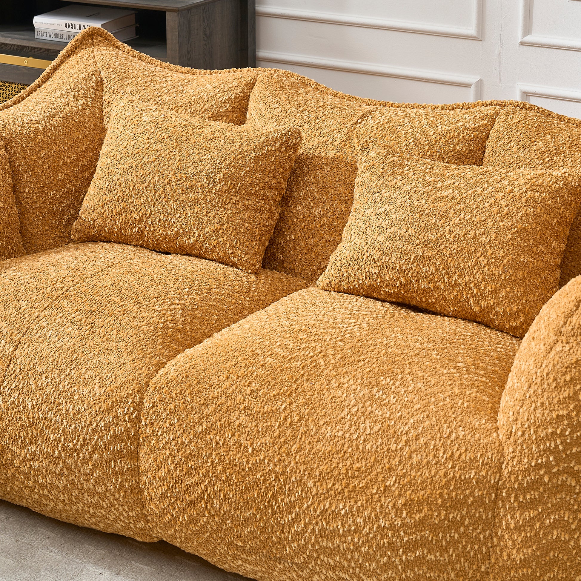 Textured ochre boucl sofa with two matching accent pillows for a cozy living room