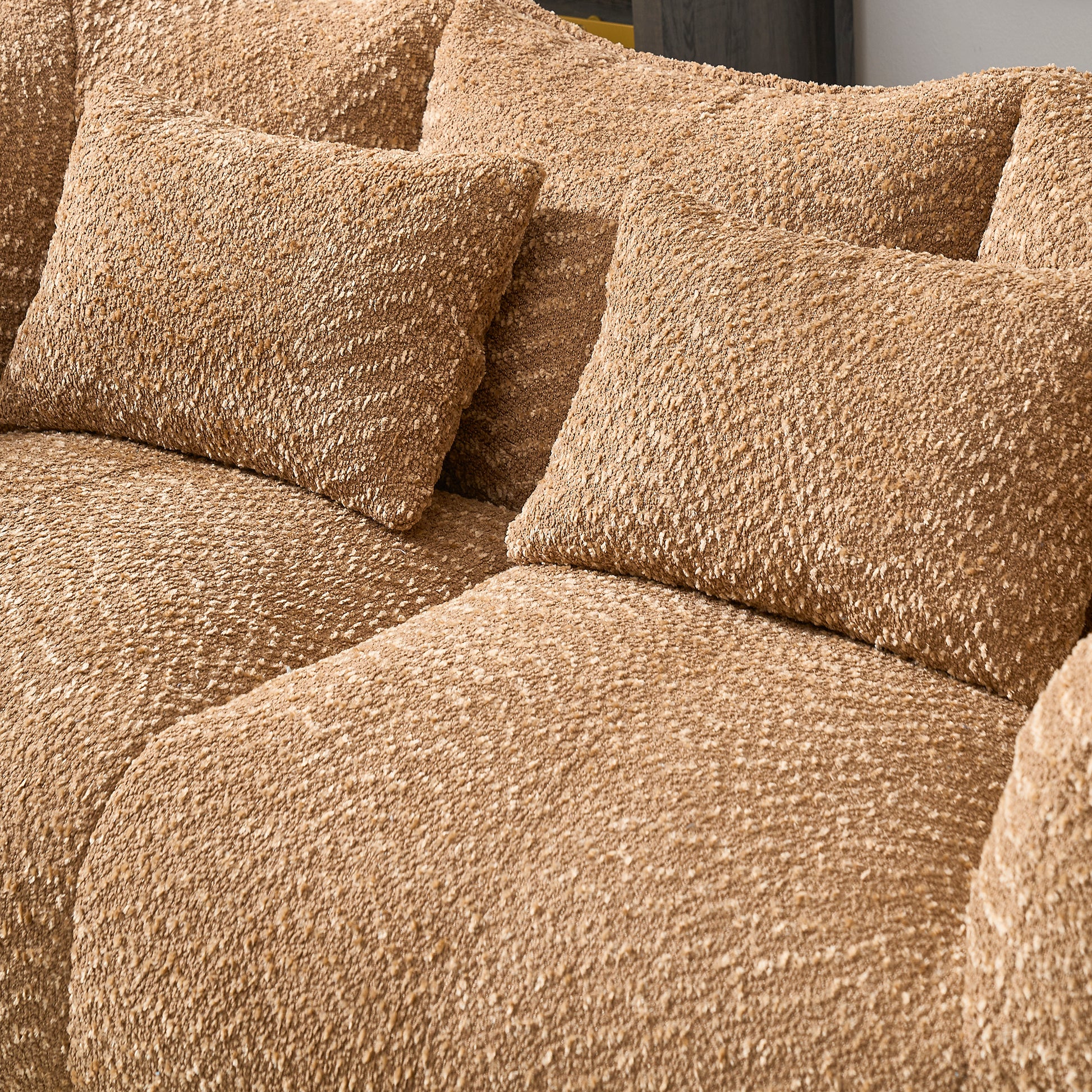 Closeup of a plush textured brown boucle fabric on a sectional sofa