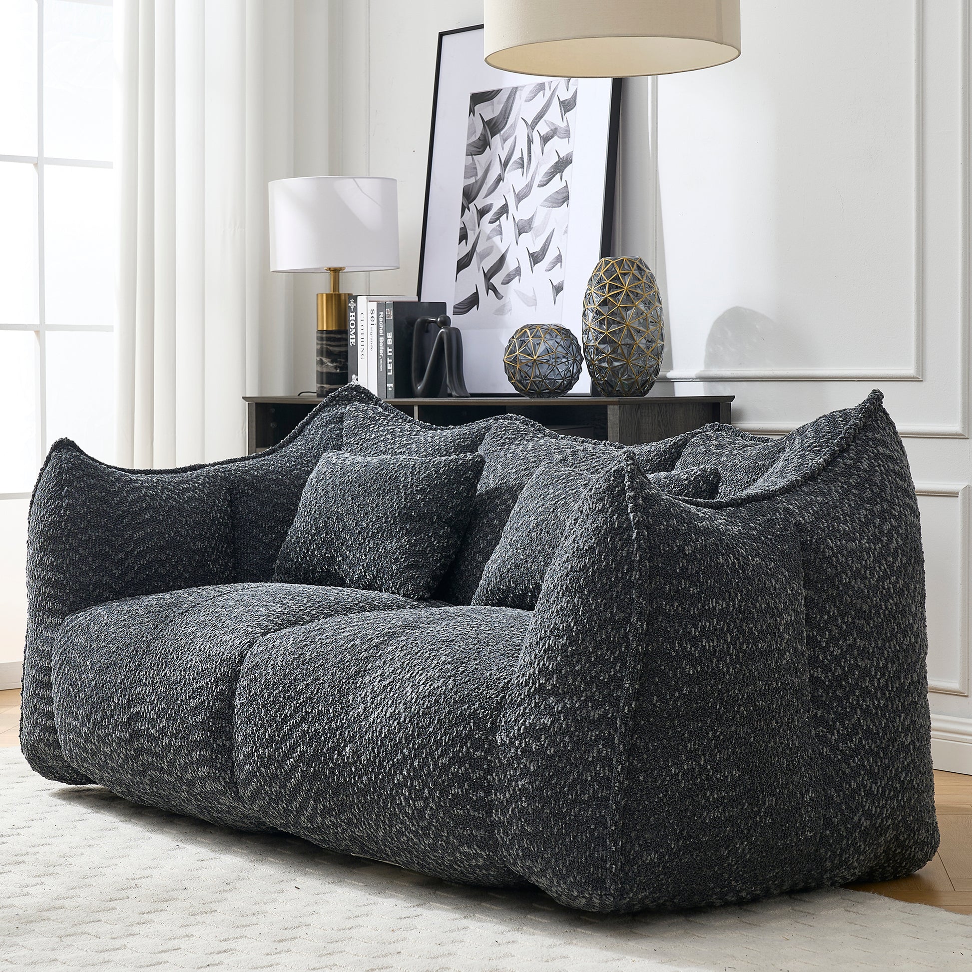 Plush charcoal grey boucl sofa with deep seating and matching throw pillows
