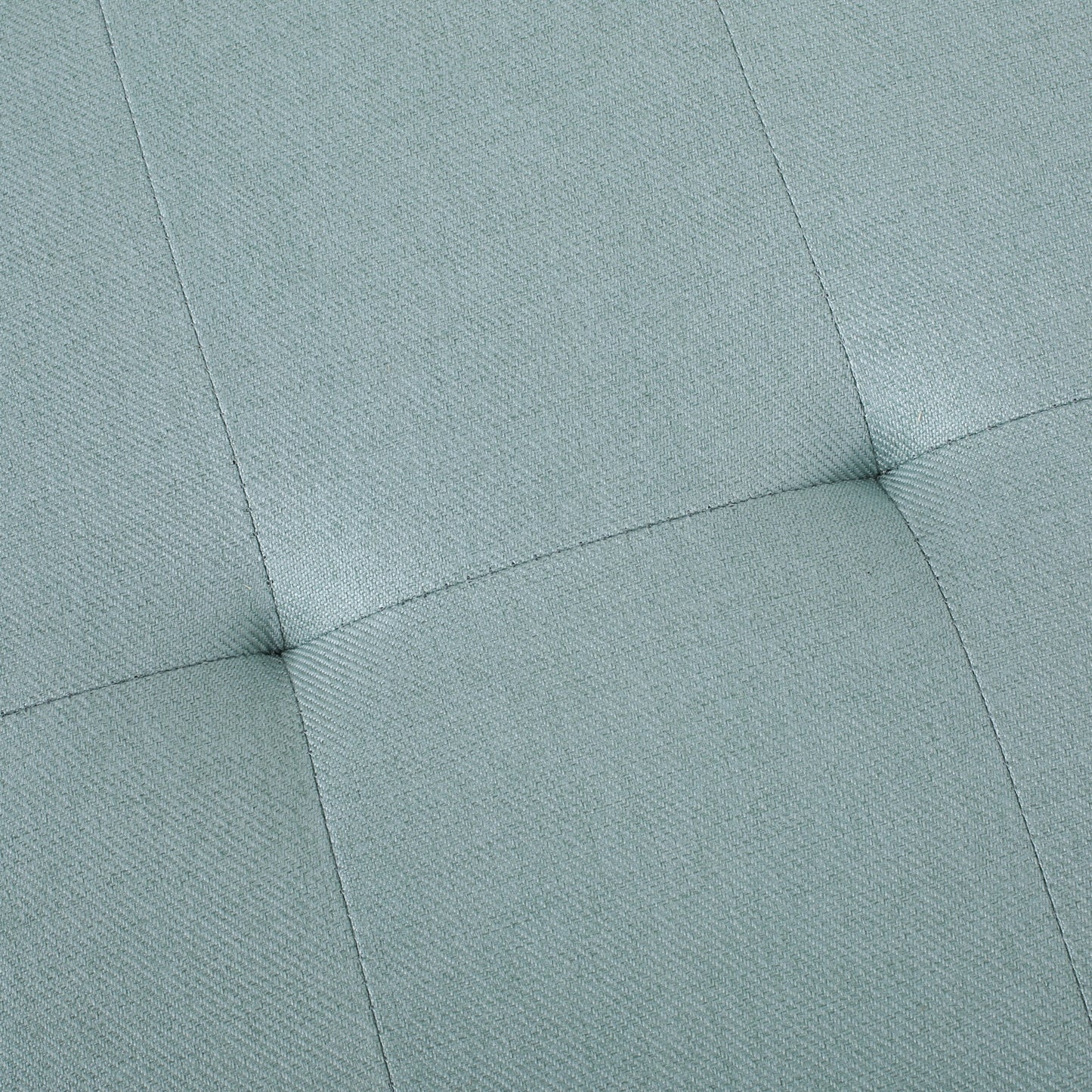 Closeup of light teal upholstered fabric with diamond tufting detail
