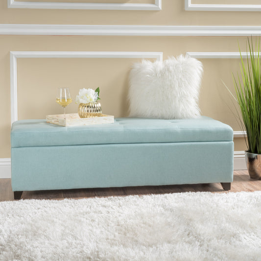 Light blue tufted storage ottoman with dark wood legs perfect for entryways