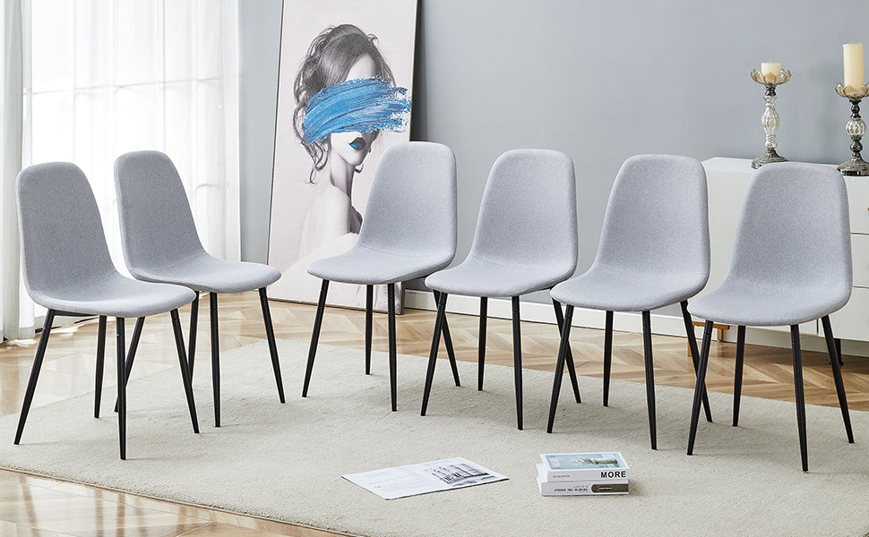 Six light gray upholstered dining chairs with black metal legs on a rug