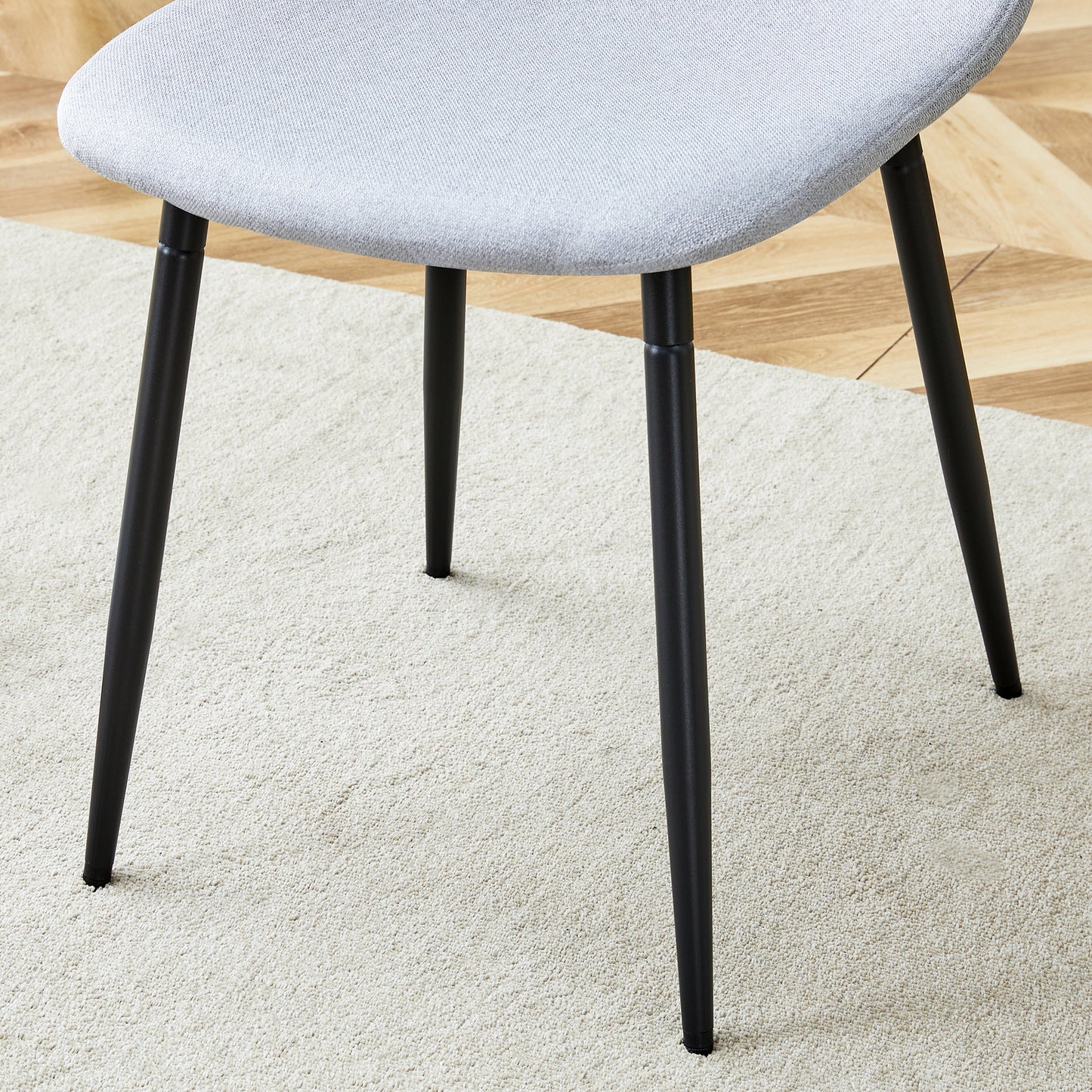 Light gray upholstered modern chair with black metal legs