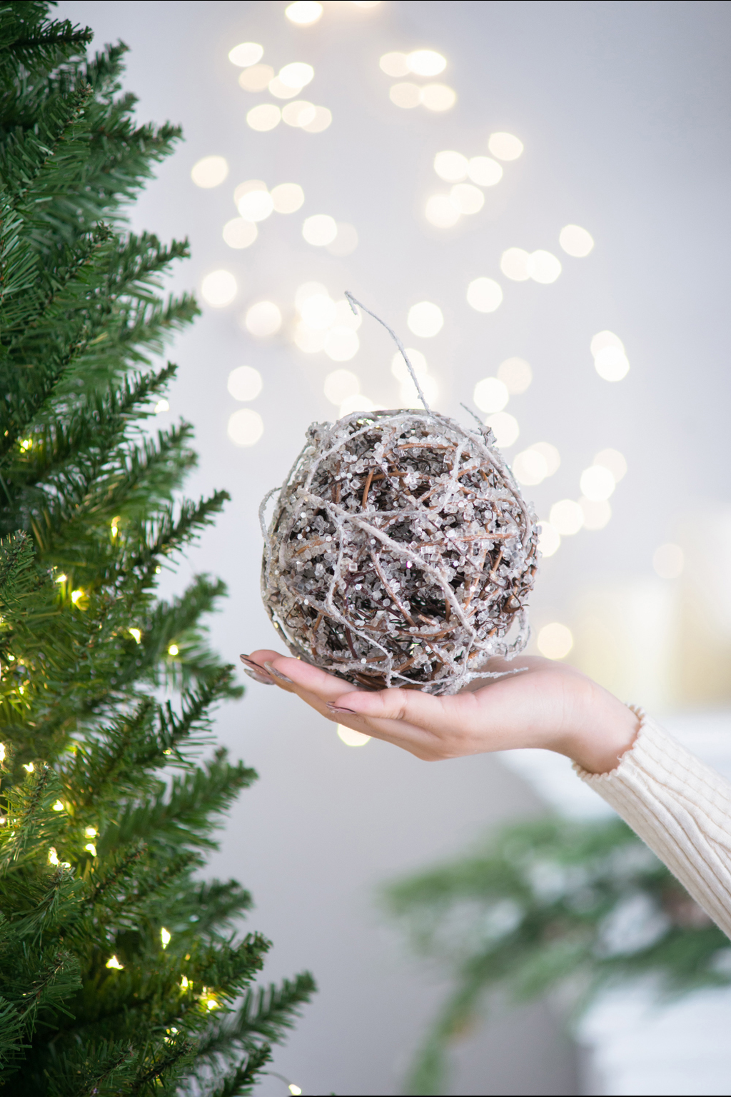 Textured twig and crystal Christmas ornament held in a hand