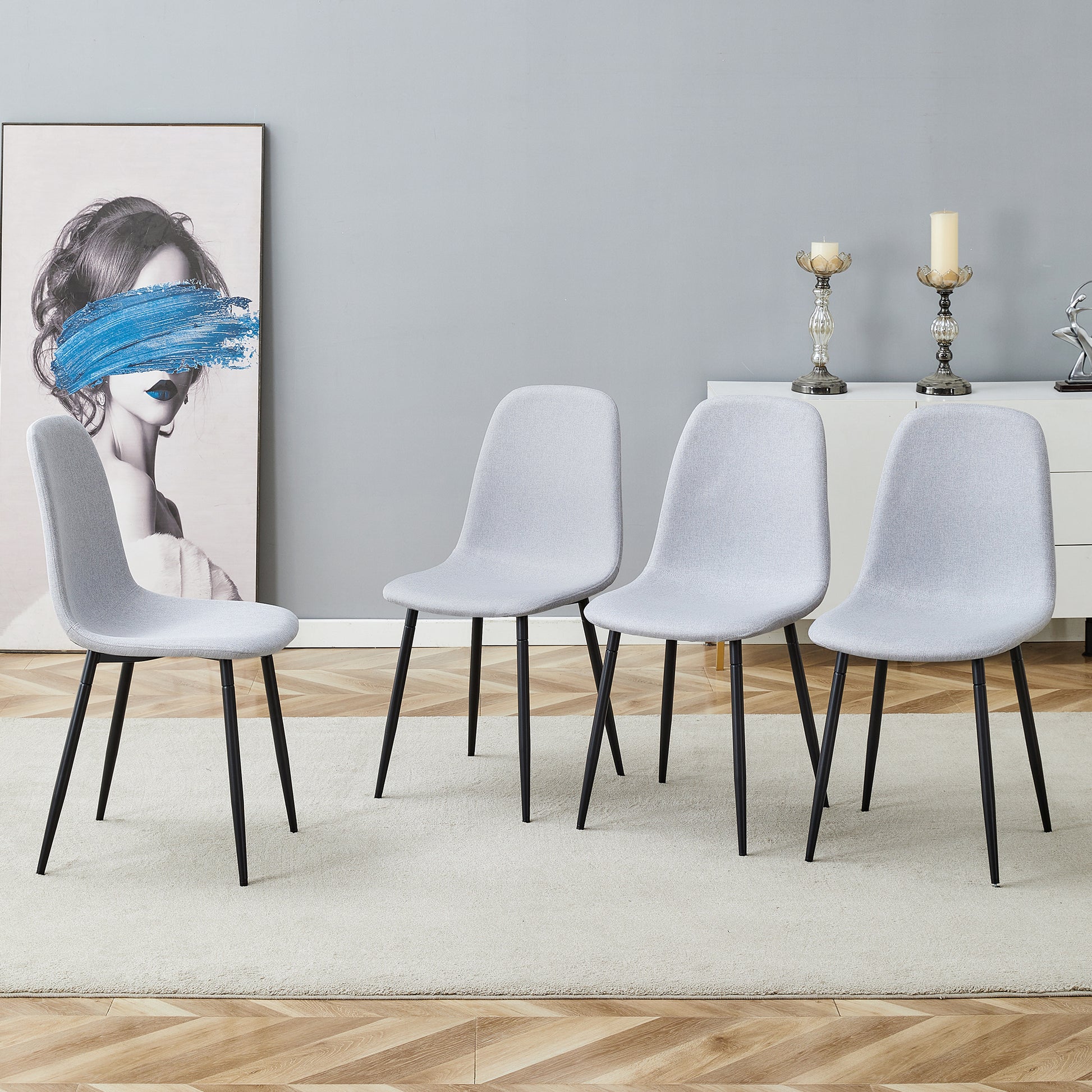 Four grey upholstered dining chairs with black metal legs