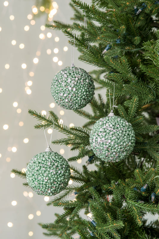 Three sparkling green sequin Christmas tree ornaments each with tiny silver beads and hanging loops