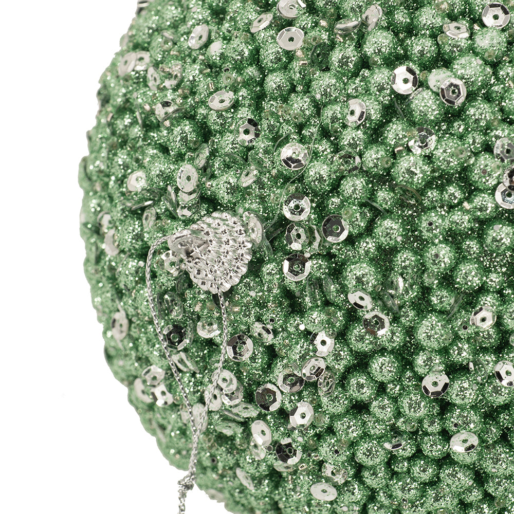 Closeup of a sparkling green Christmas ornament adorned with silver sequins