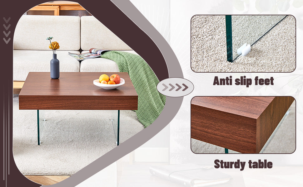 Modern coffee table with dark wood finish glass legs and a bowl of fruit