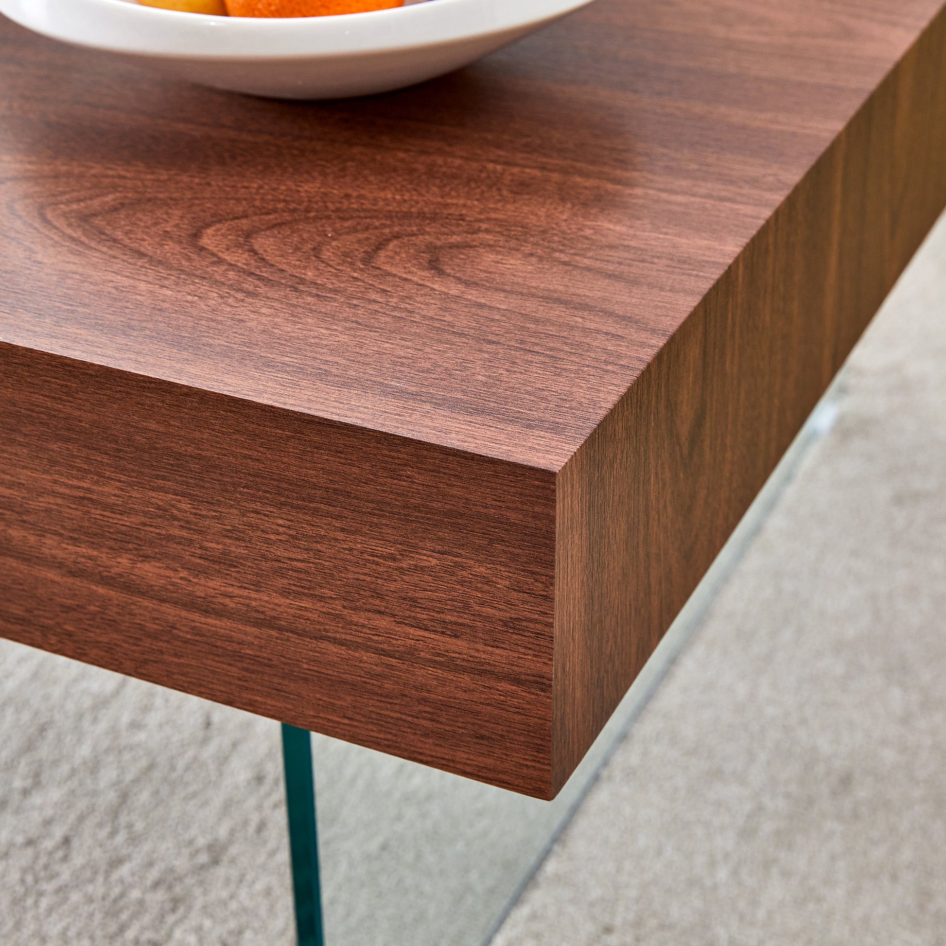 Rich walnut veneer coffee table with a sleek modern design and glass legs