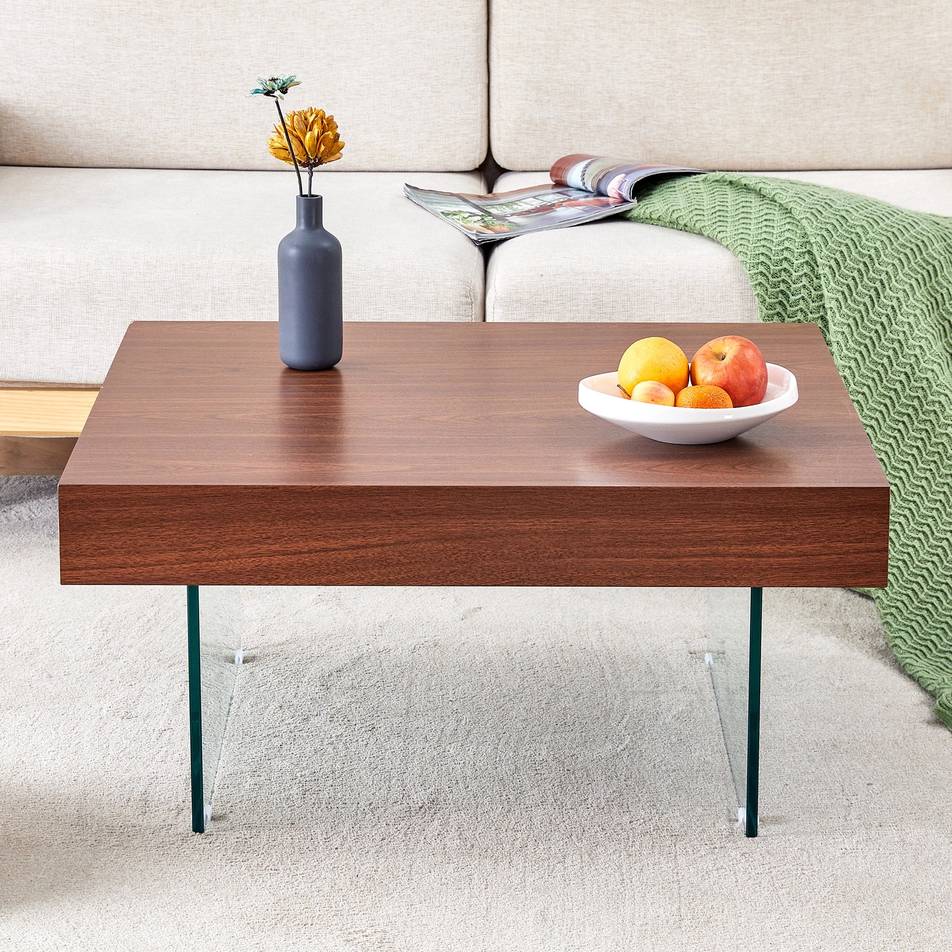 Rich walnut veneer coffee table with clear glass legs and a modern minimalist design