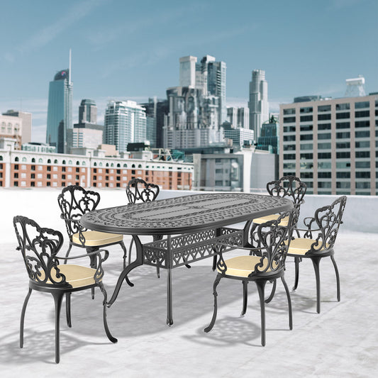 Black cast aluminum oval dining table with ornate detailing and six chairs