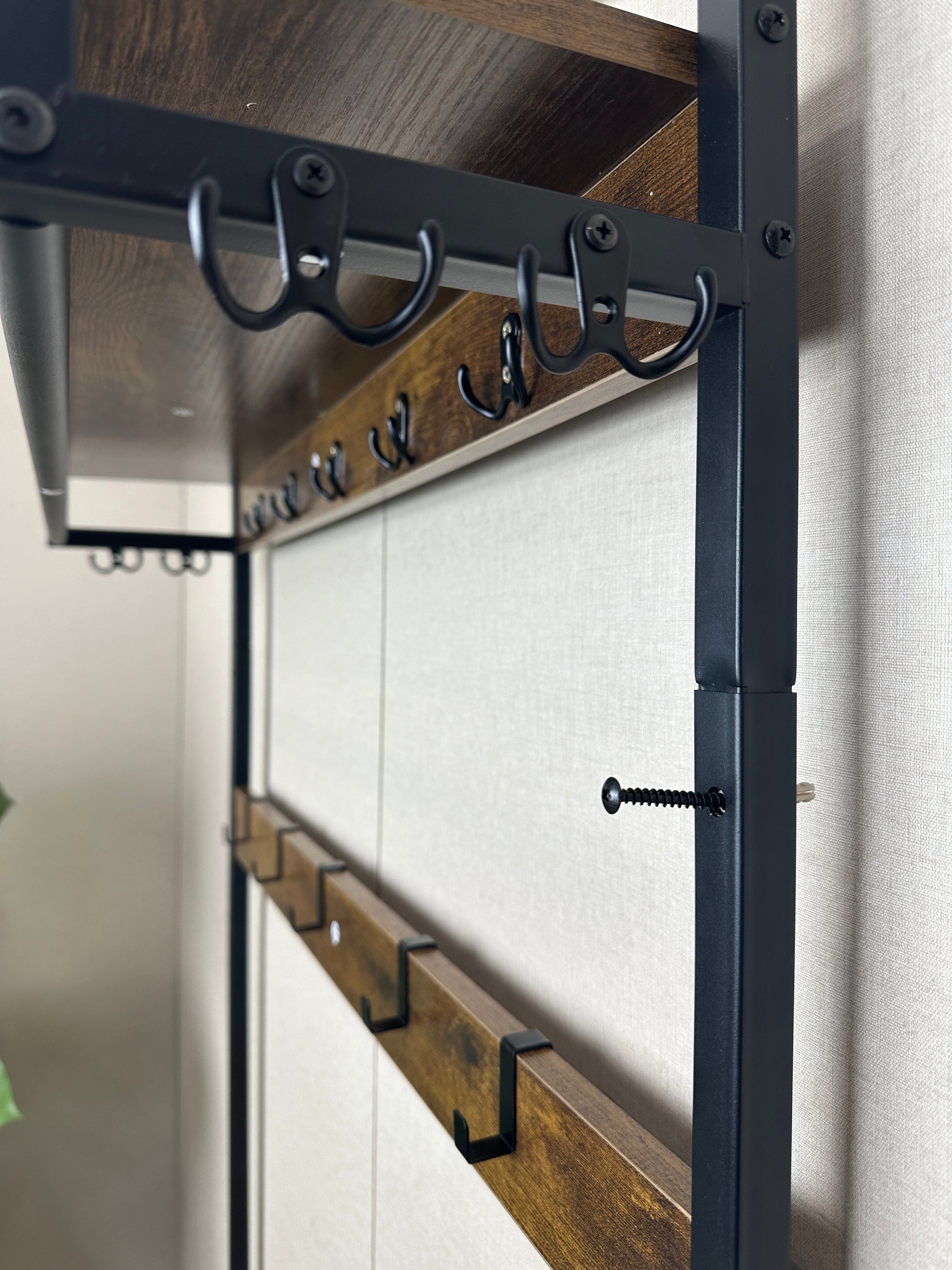 Industrial style metal coat rack with rustic wood shelves and black hooks