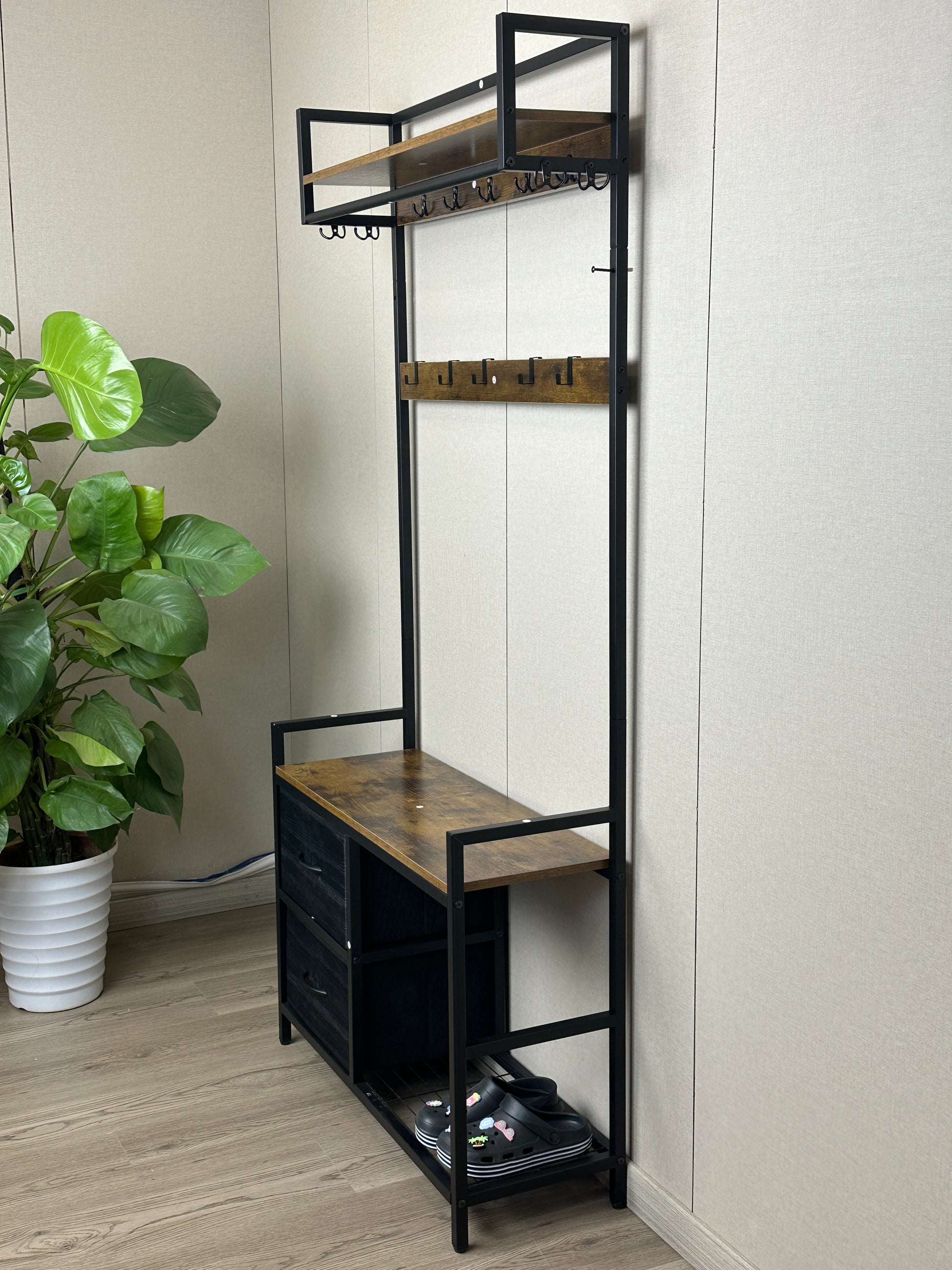 Industrial entryway hall tree with wood shelves and black metal frame featuring coat hooks and shoe storage