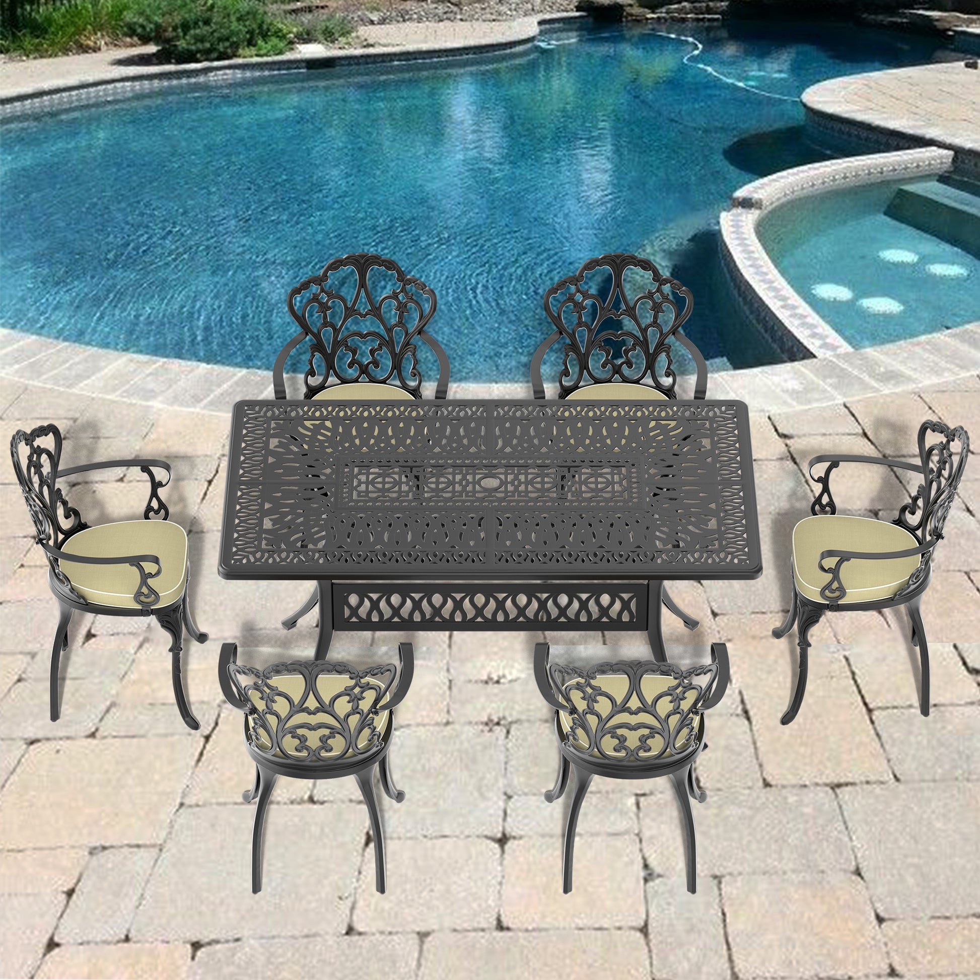 Black ornate cast aluminum dining set with four chairs and a table by a pool