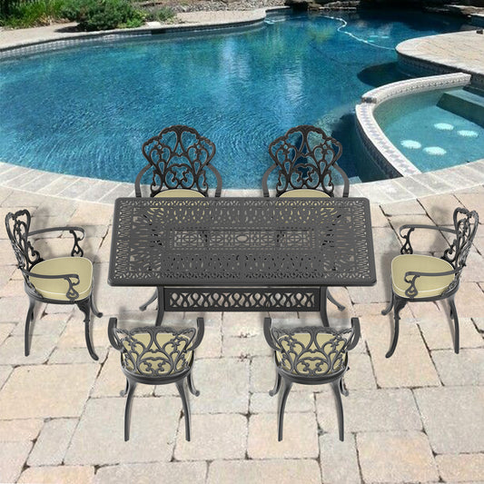 Black ornate cast aluminum dining set with four chairs and a table by a pool