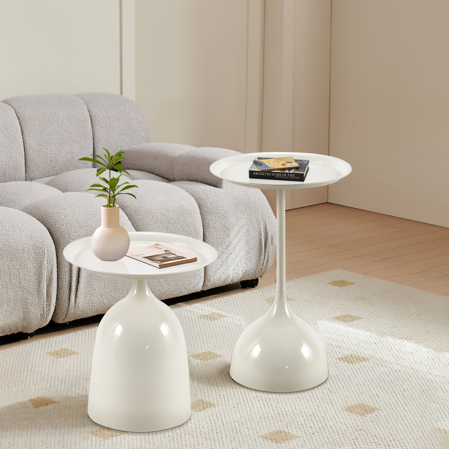 Two modern white pedestal accent tables beside a grey sofa