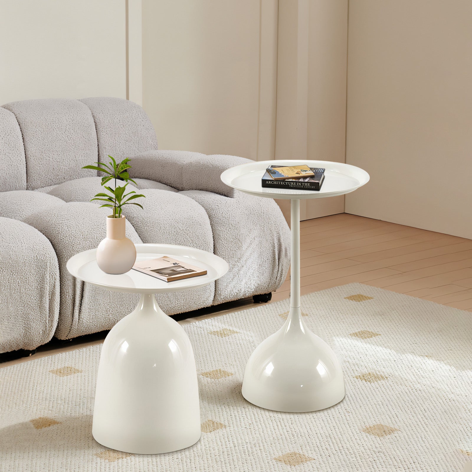 Two modern white pedestal accent tables beside a grey sofa