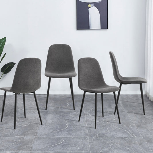 Four modern grey fabric dining chairs with black metal legs arranged around a table