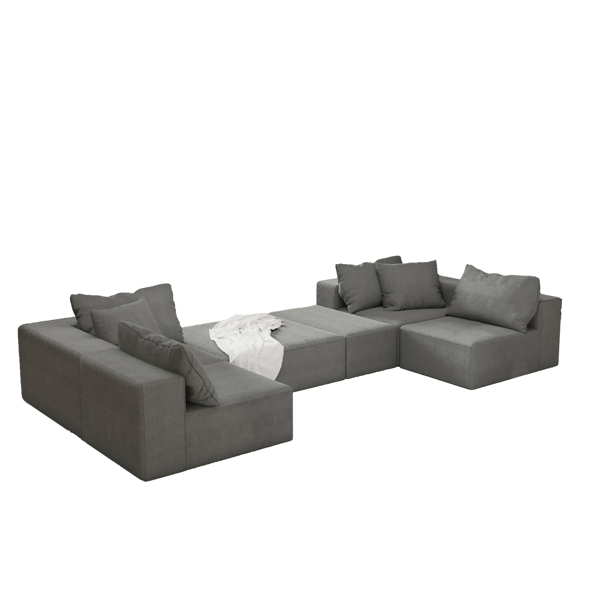 Modern charcoal grey sectional sofa with plush cushions and an ottoman on a textured rug