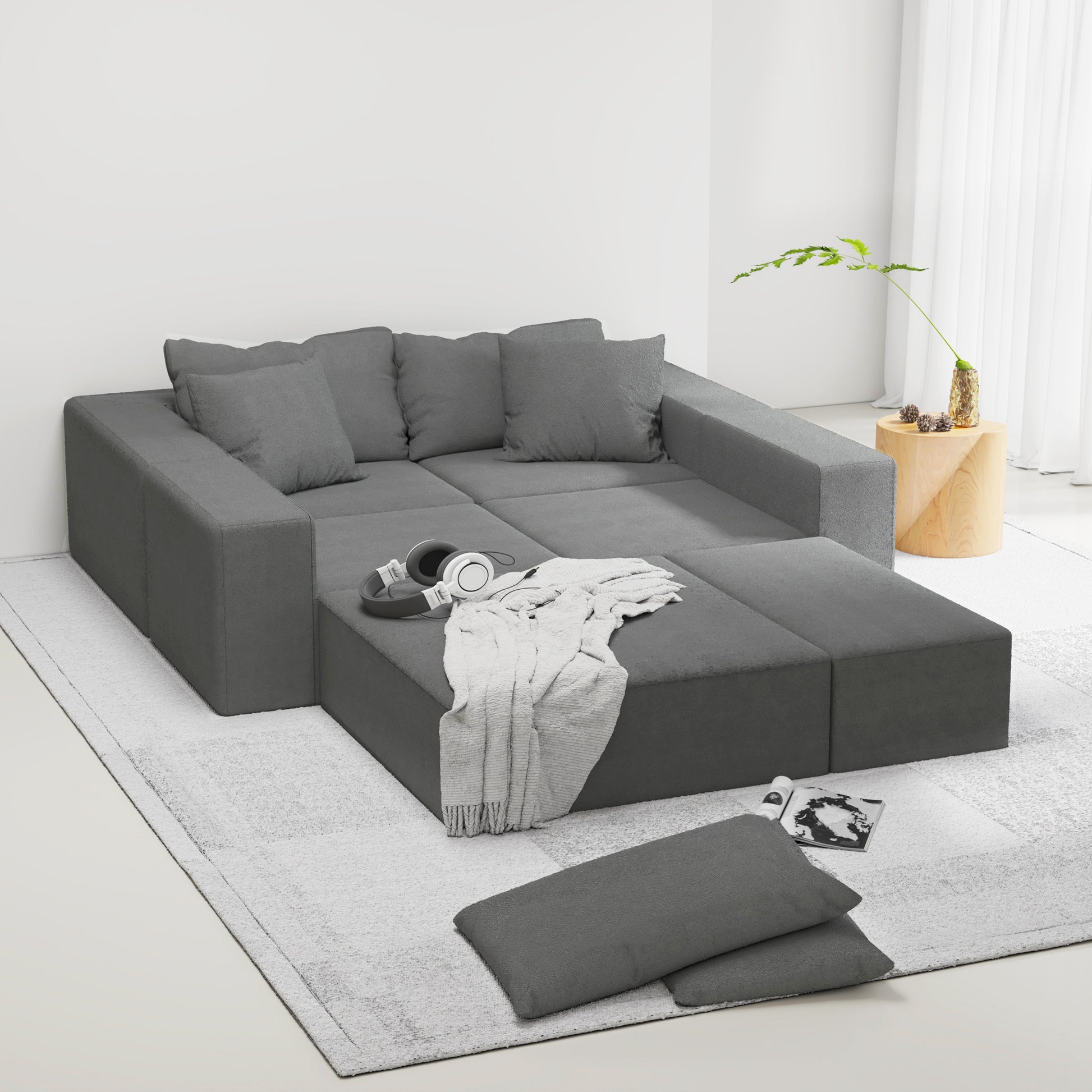 Modular charcoal gray sectional sofa with plush cushions and textured throw