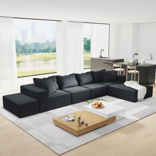 Dark gray sectional sofa with plush cushions and an ottoman on a modern rug perfect for living rooms