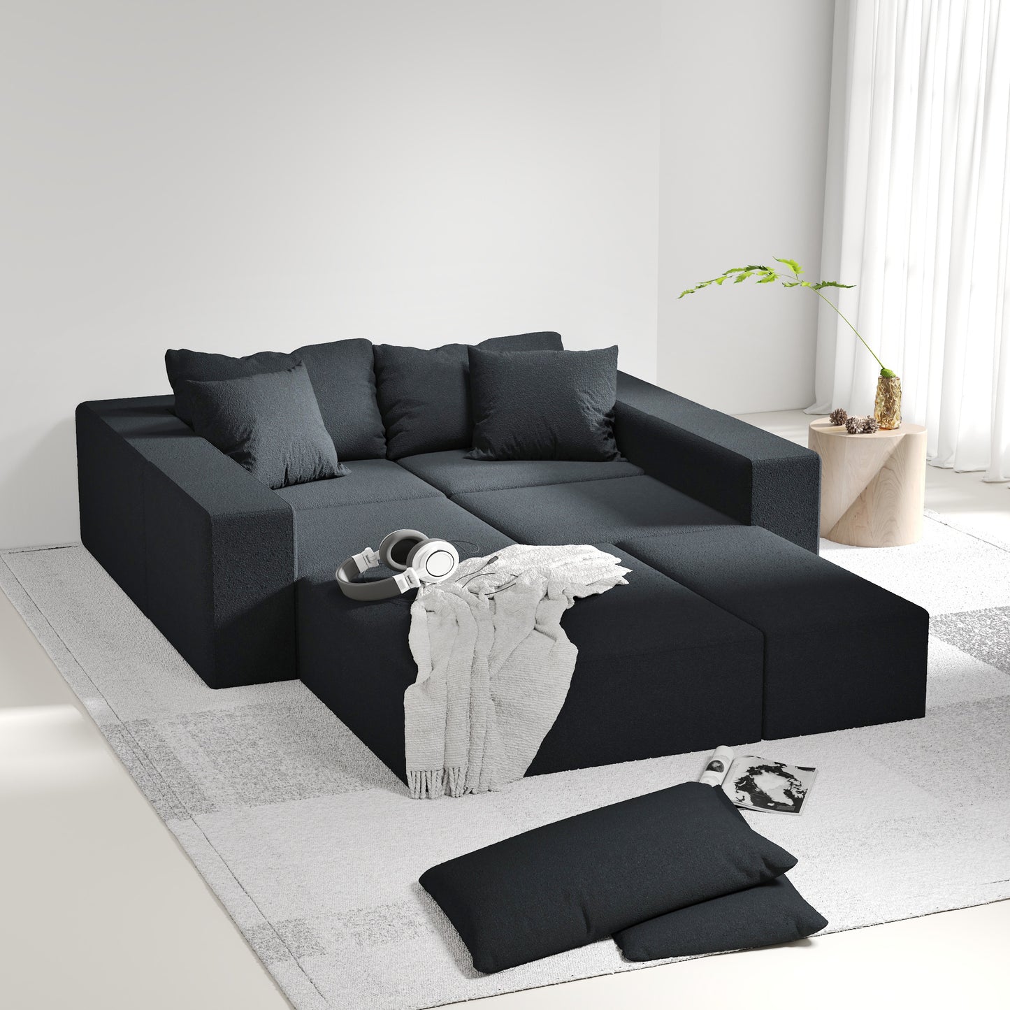 Modern dark grey modular sectional sofa with plush throw pillows and a soft blanket