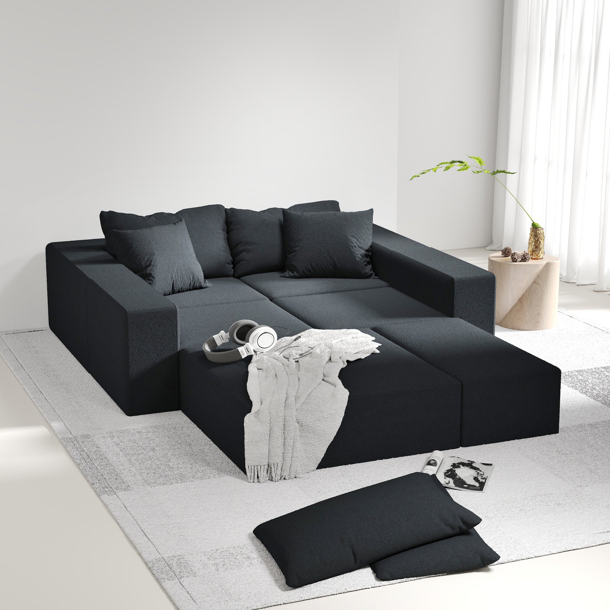 Modern dark grey modular sectional sofa with plush throw pillows and a soft blanket