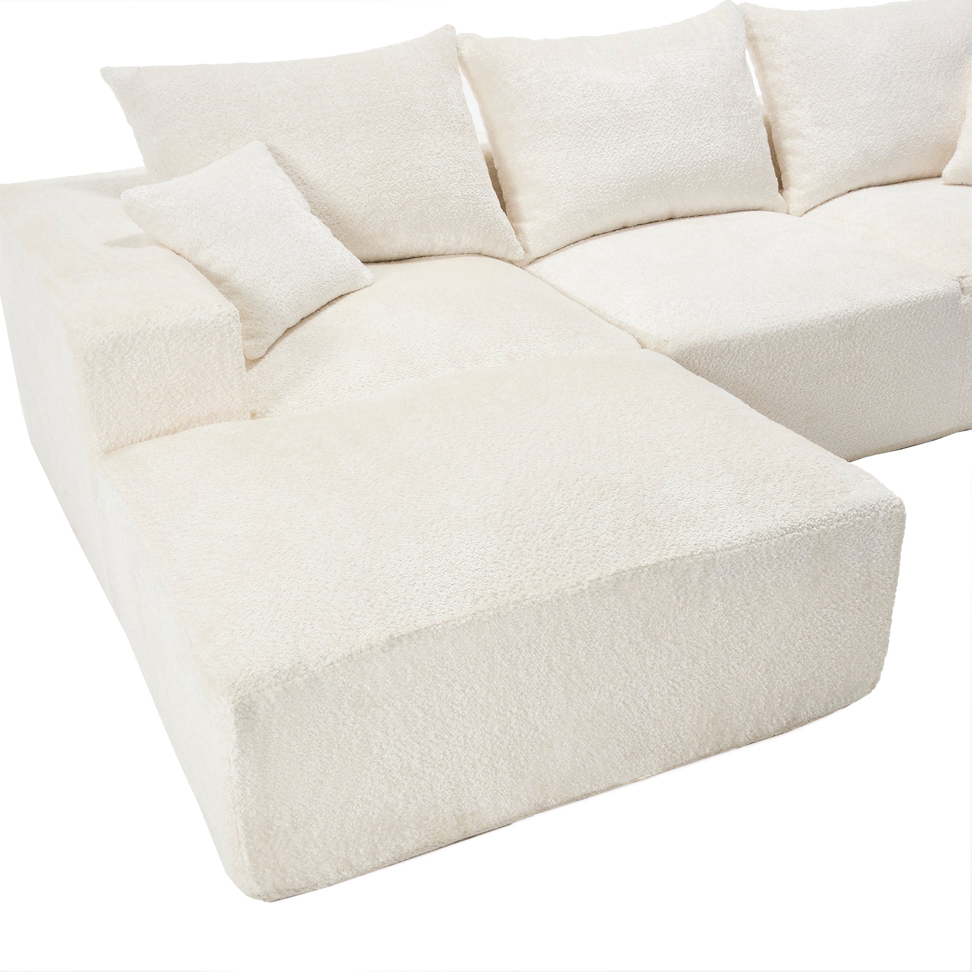 Cream boucle sectional sofa with plush throw pillows perfect for a cozy living room