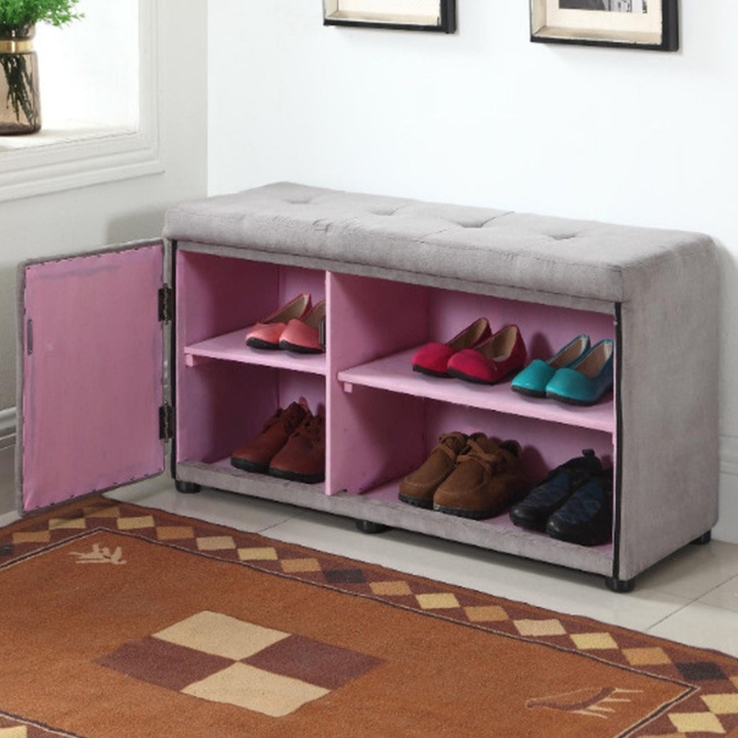 Grey upholstered storage bench with pink interior holding various shoes