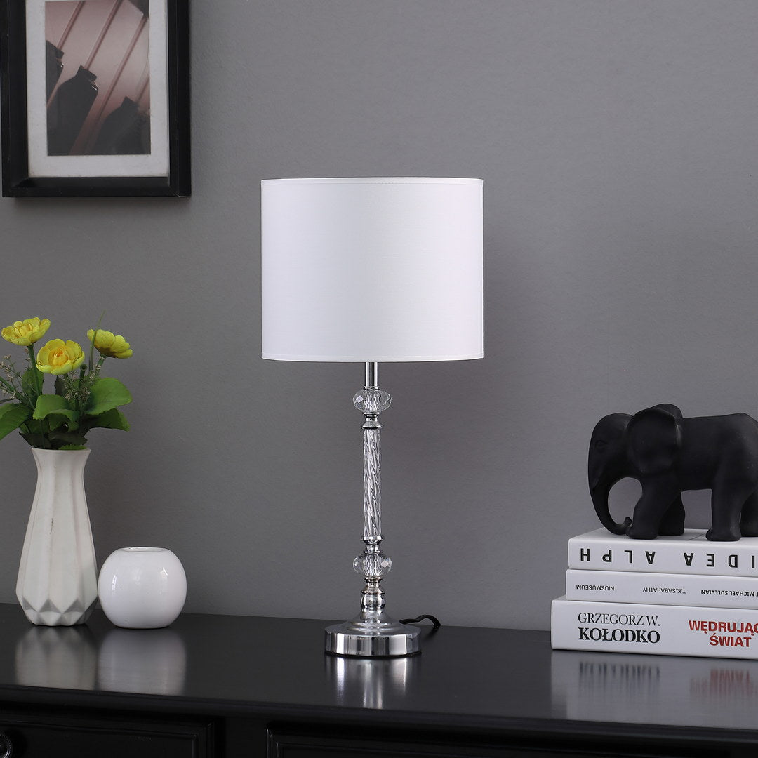 Elegant clear crystal table lamp with white drum shade perfect for bedside illumination