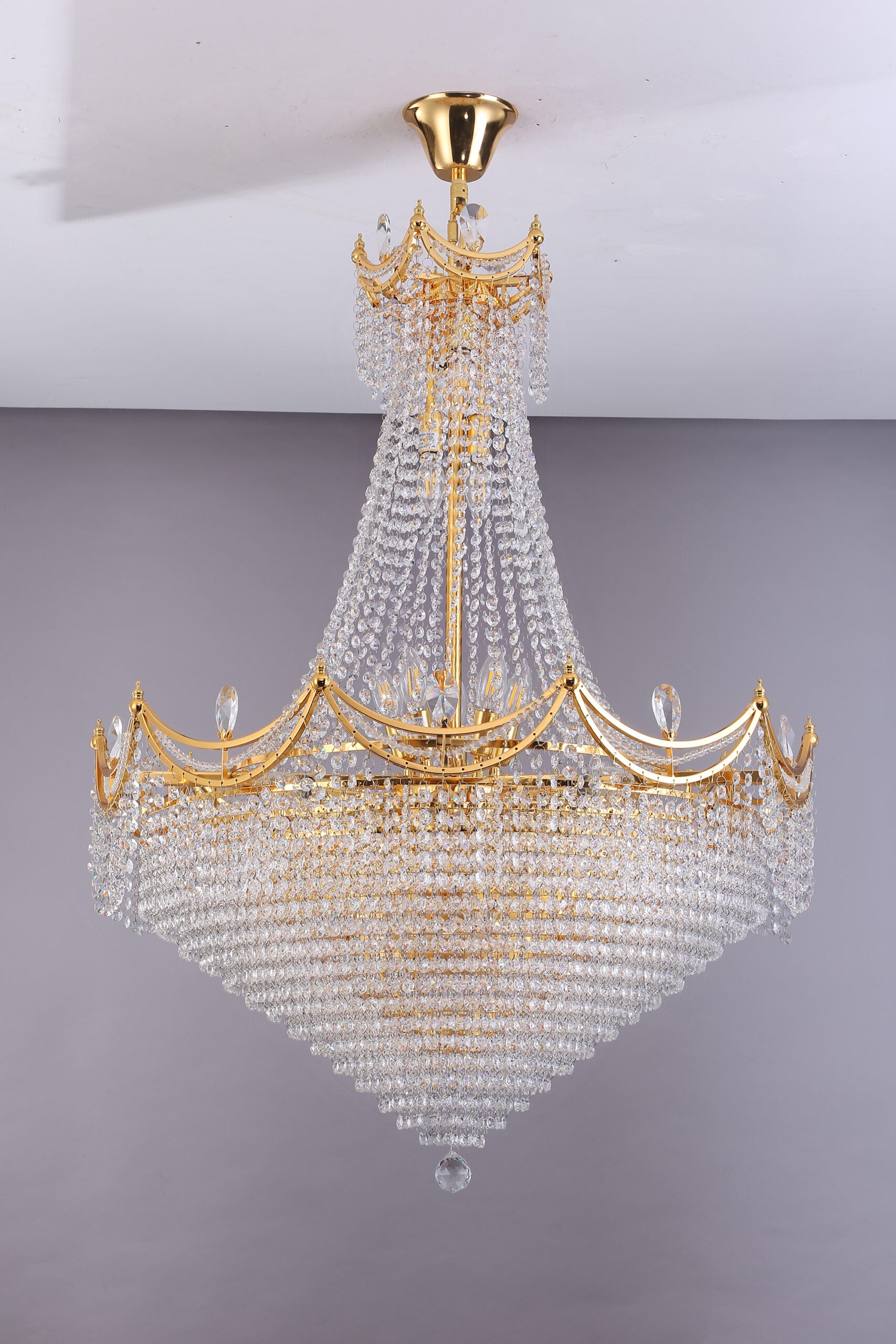 Large gold crystal chandelier with cascading faceted prisms and a tiered design