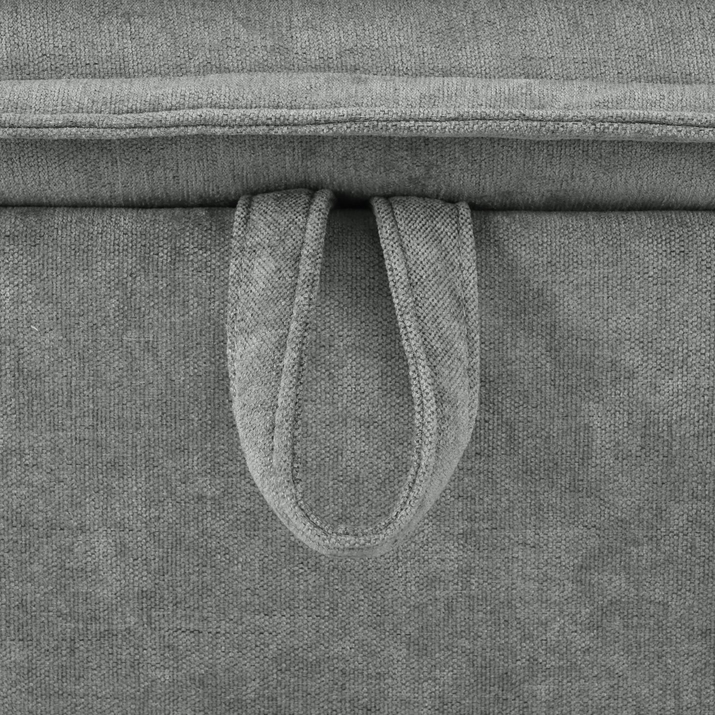 Closeup of a gray fabric ottoman with a looped handle for easy transport and storage