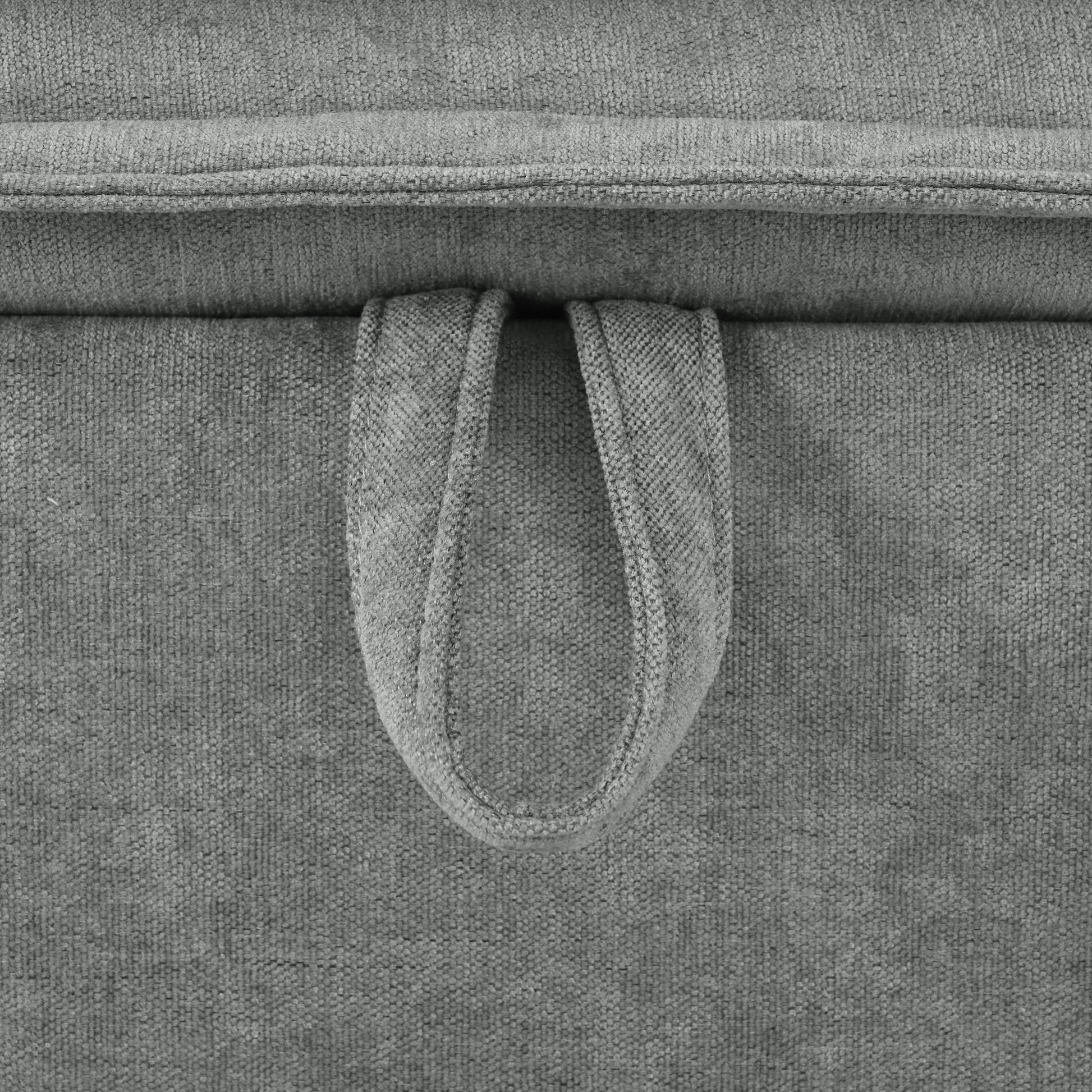 Closeup of a gray fabric ottoman with a looped handle for easy transport and storage