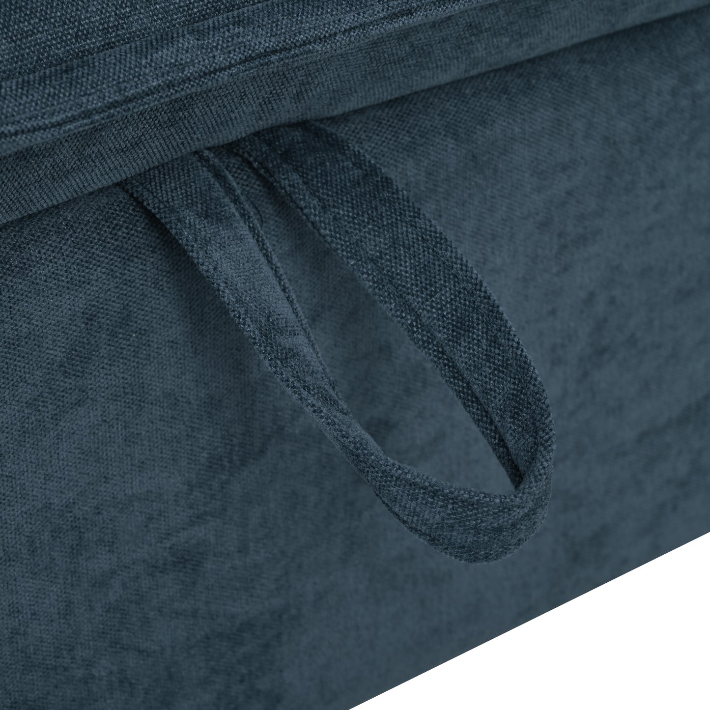 Closeup of a dark blue fabric ottoman with a pull strap for easy lifting