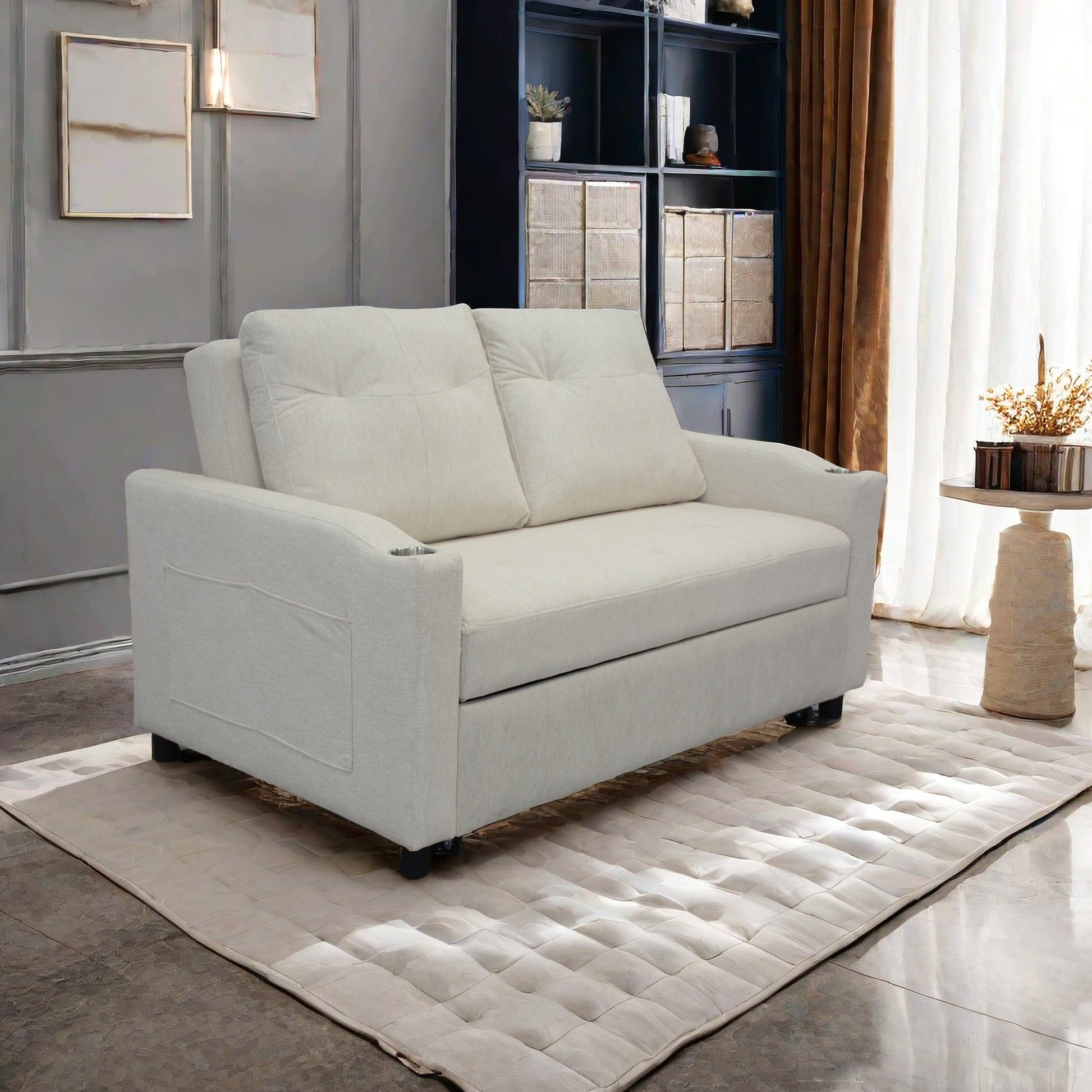 Cream upholstered sofa bed with tufted seat cushions and side pocket storage