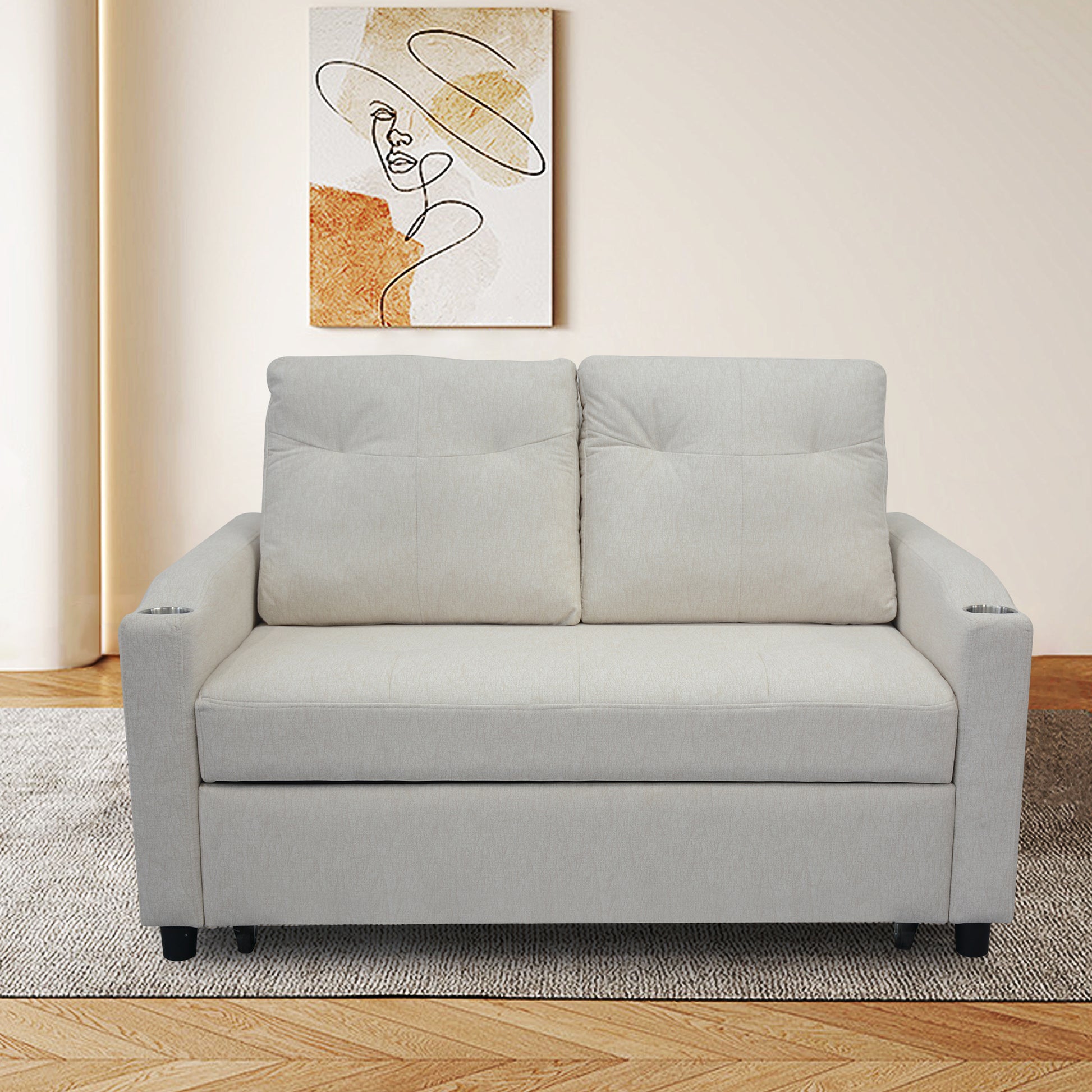 Light beige upholstered sofa with two pillows and builtin cup holders