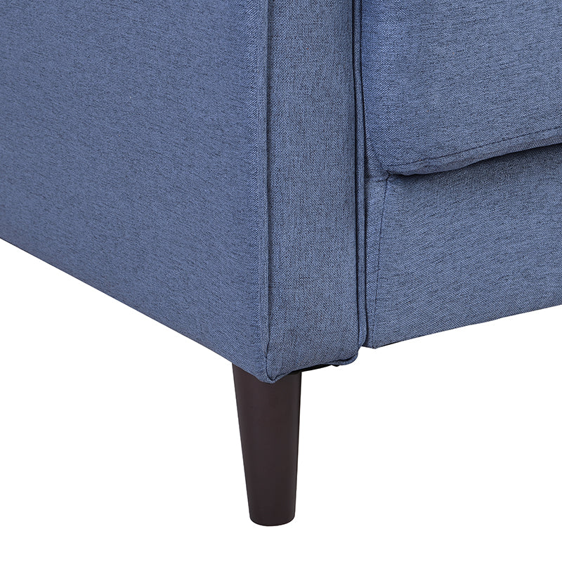 Close up of blue fabric sofa armrest with dark wooden tapered leg